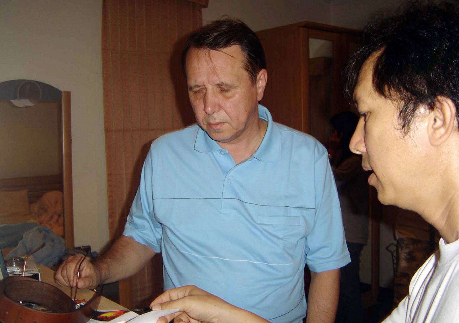 Pletnev, de 53 años, habla con un policía en su residencia de la ciudad turística de Pattaya en Tailandia.