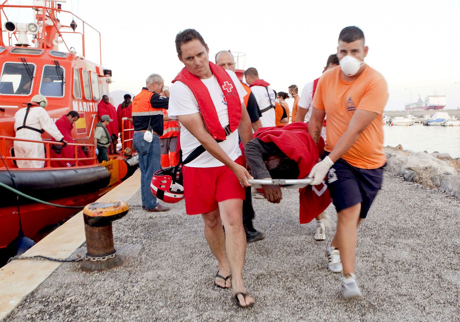 Evacuación en el puerto de Motril de uno de los ocupantes de la patera hundida.