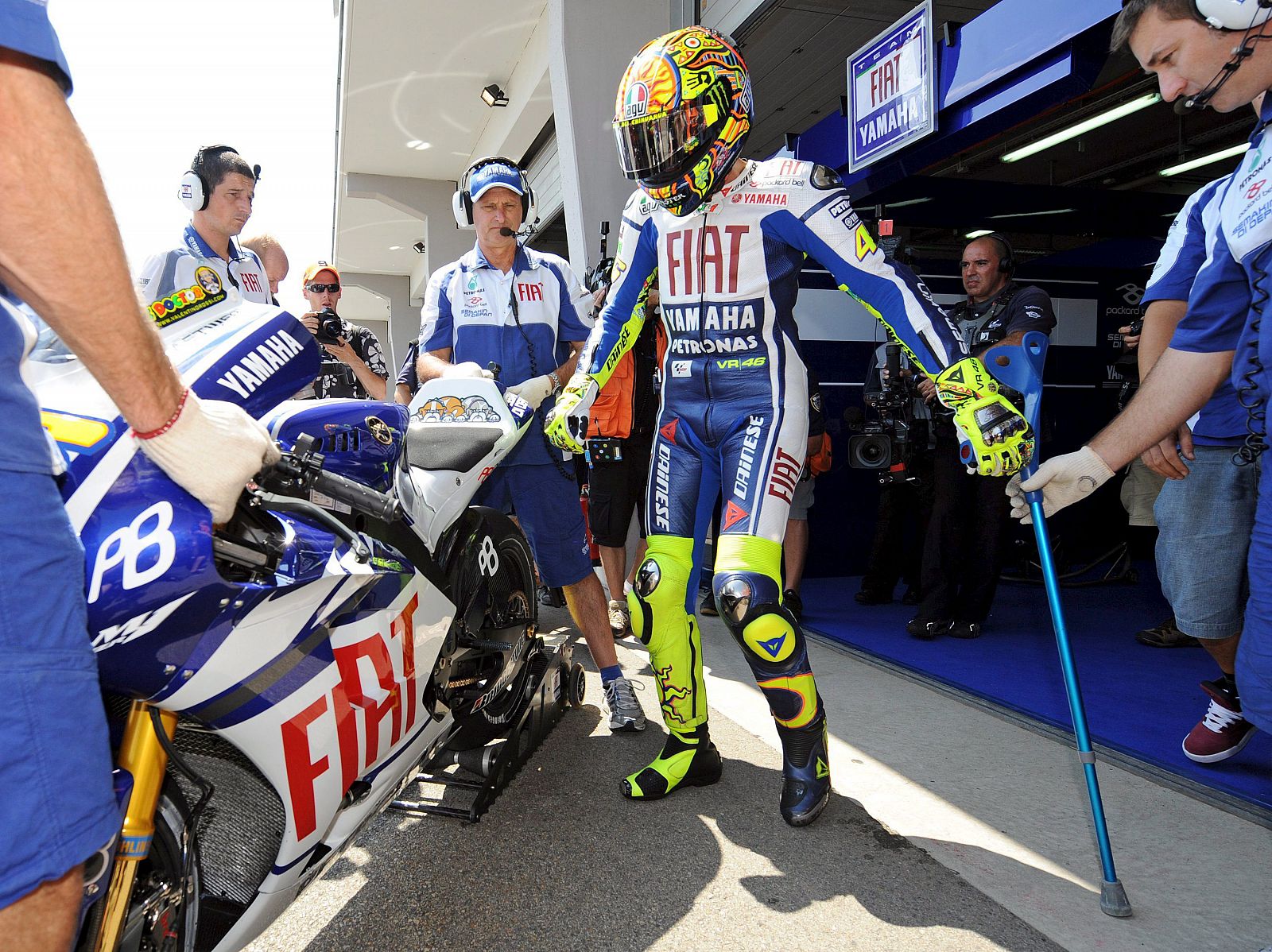 Valentino Rossi se ayuda con unas muletas tras bajarse de la moto.
