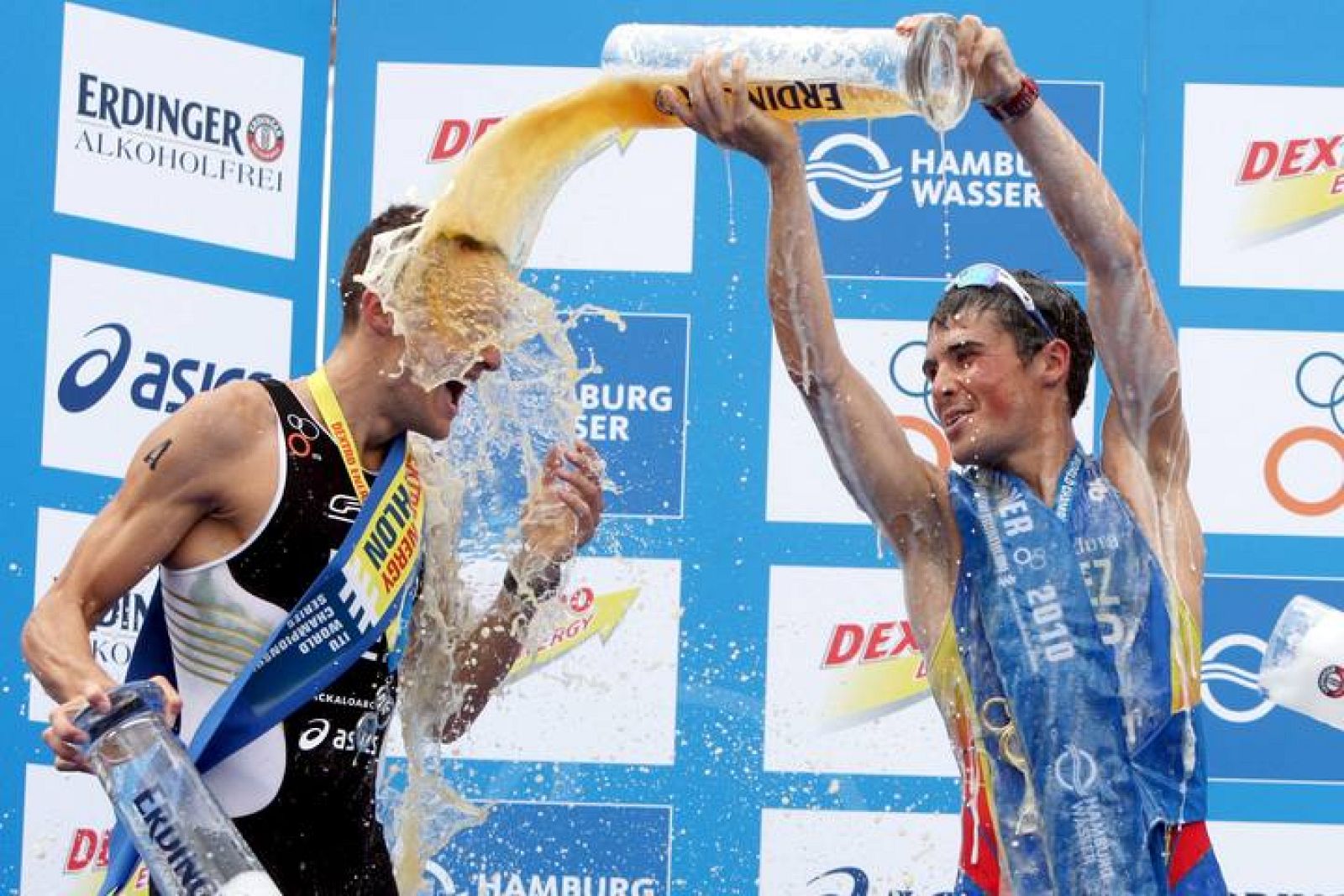 El español Javier Gómez Noya, (d), celebra junto al alemán Jan Frodeno, (i), tras ganar la cuarta prueba del Mundial de triatlón, en Hamburgo, (Alemania).