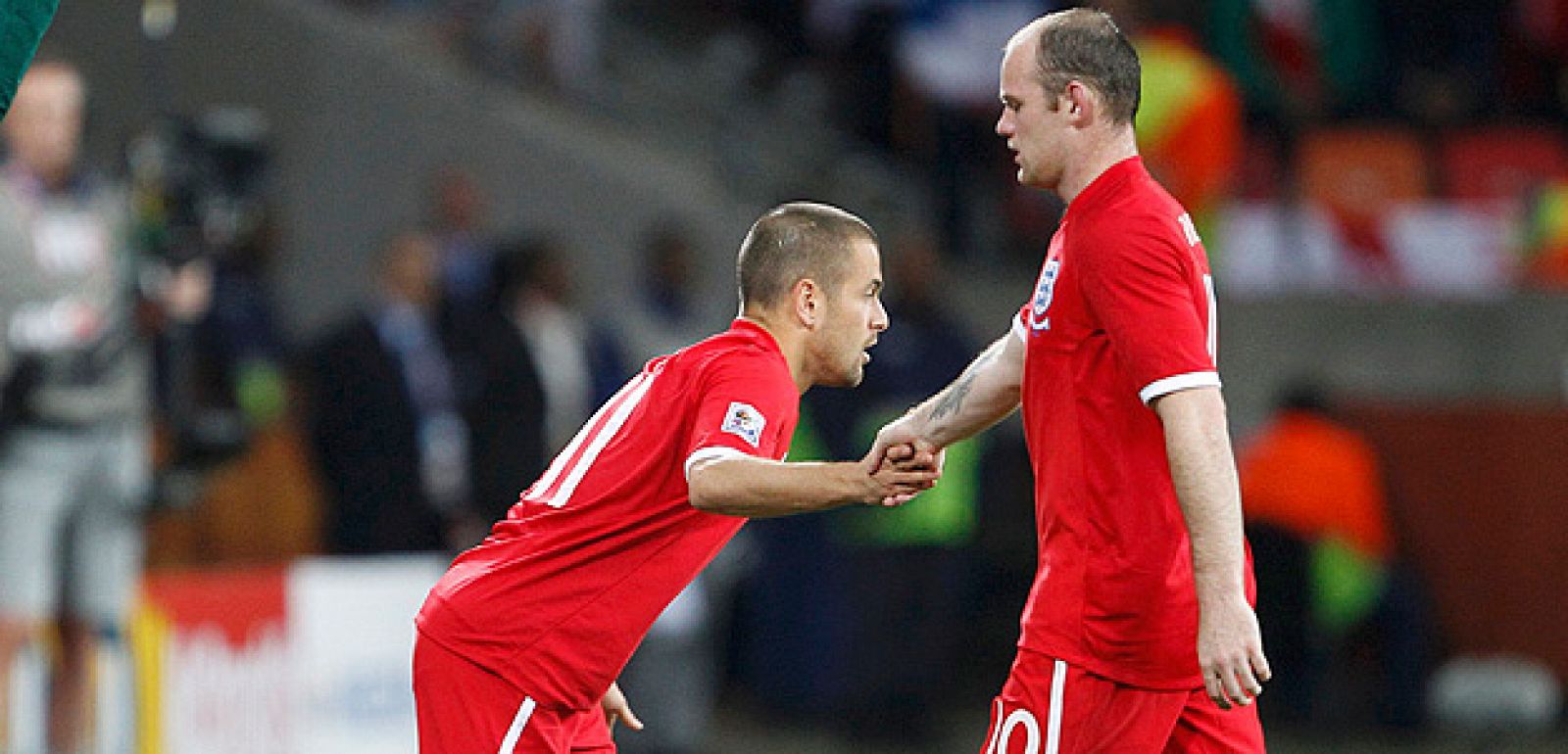 Joe Cole salta al campo en sustitución de Rooney, quien le estrecha la mano, en un partido de la selección inglesa