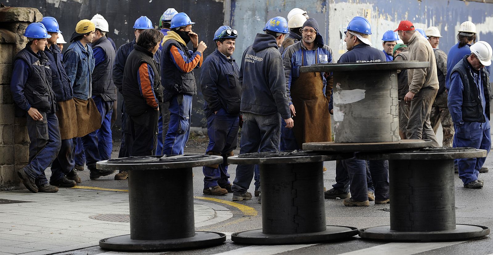 Shipyard workers roll a barricade during a protest in Gijon, northern Spain