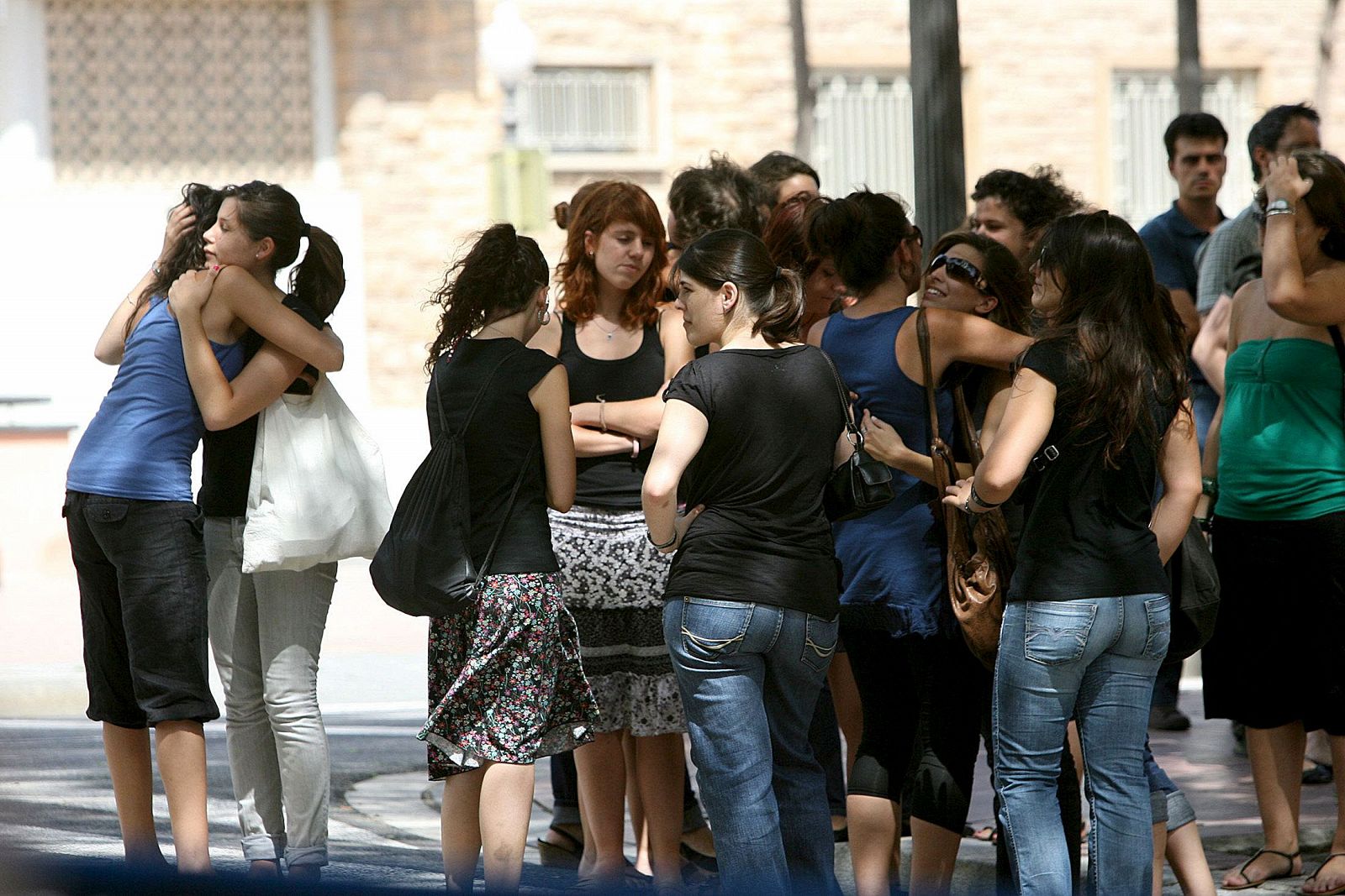 Amigas de Clara Zapater, fallecida en el Loveparade de Alemania, a las puertas de la iglesia donde se ha celebrado su funeral.