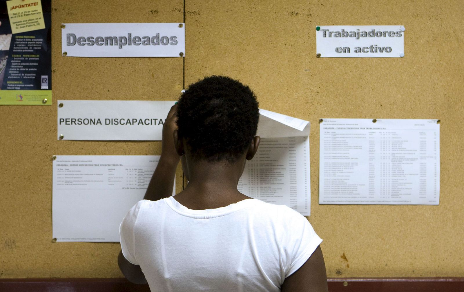 Una mujer consulta el tablón de anuncios en una oficina del Instituto Aragonés de Empleo (INAEM) en Zaragoza