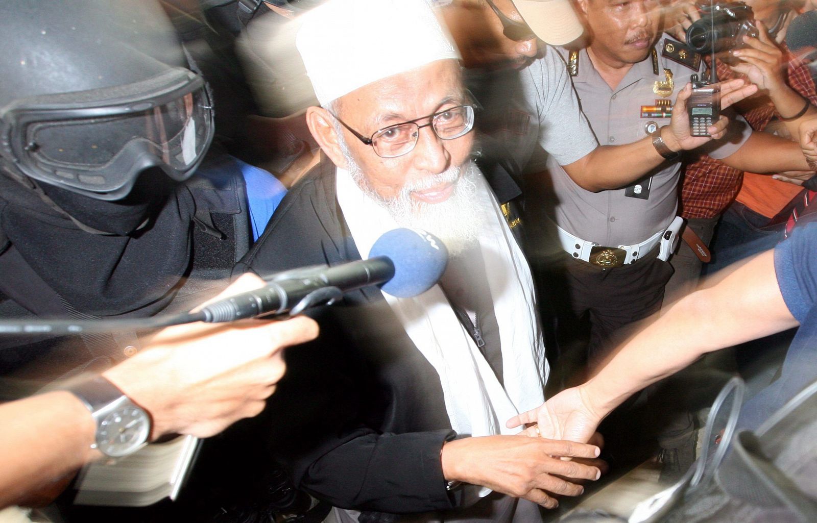 El clérigo radical Abu Bakar Bashir llega escoltado a la sede de la Policía indonesia en Yakarta (Indonesia)