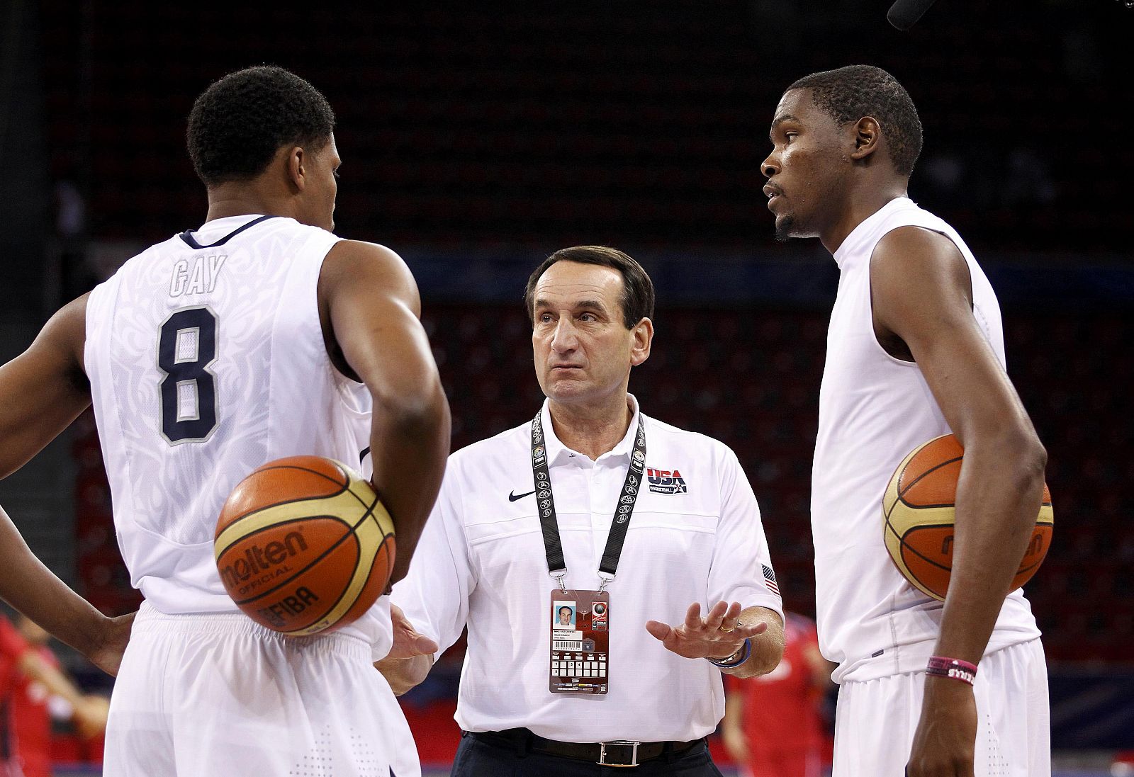 El seleccionador Mike Krzyzewski habla con Rudy Gay y Kevin Durant antes del partido.