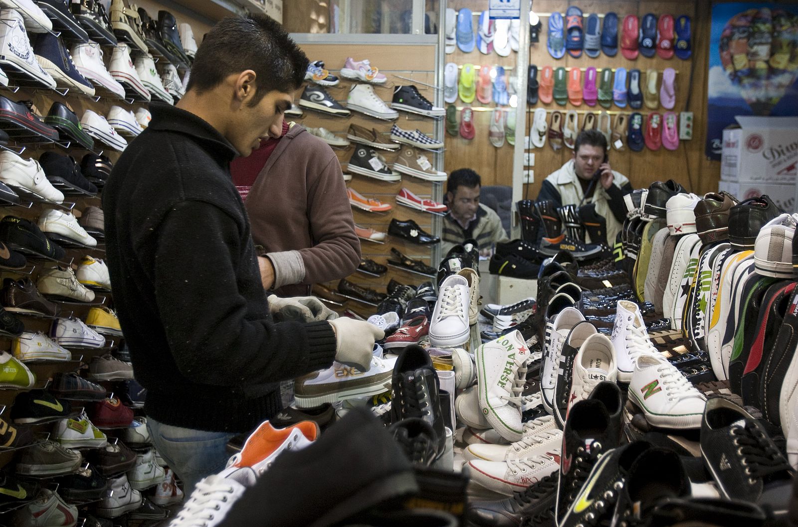 Customers look at shoes in a shop in Tehran's Grand Bazaar