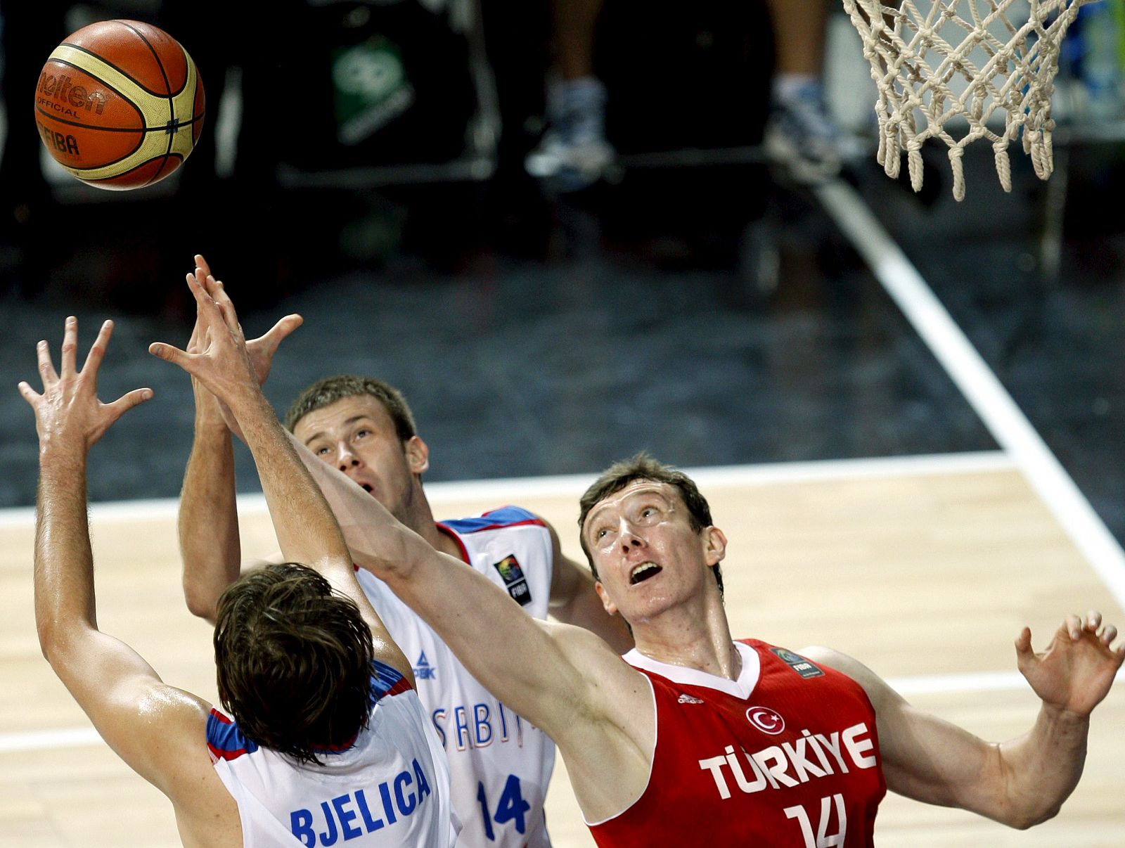 El jugador turco Omer Asik lucha por el rebote con los serbios Bjelica y Velickovic. Turquía se ha metido en la final del Mundial.