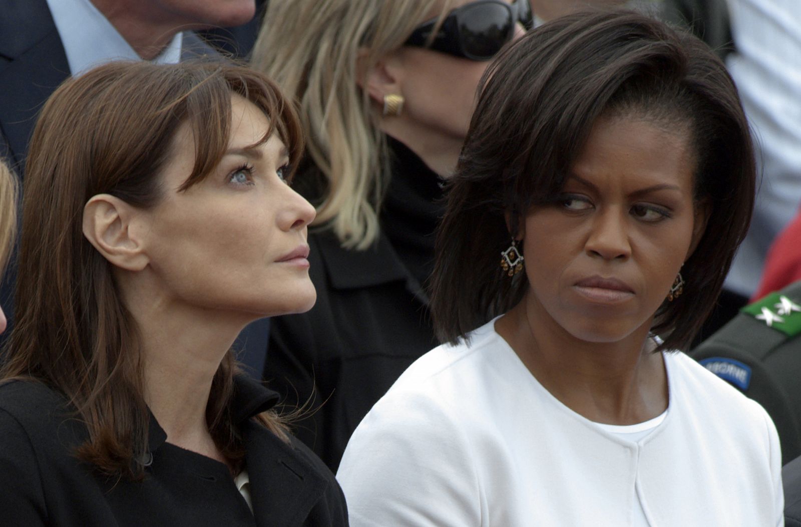 Michelle Obama mira a Carla Bruni en una ceremonia celebrada en junio en Normandía.