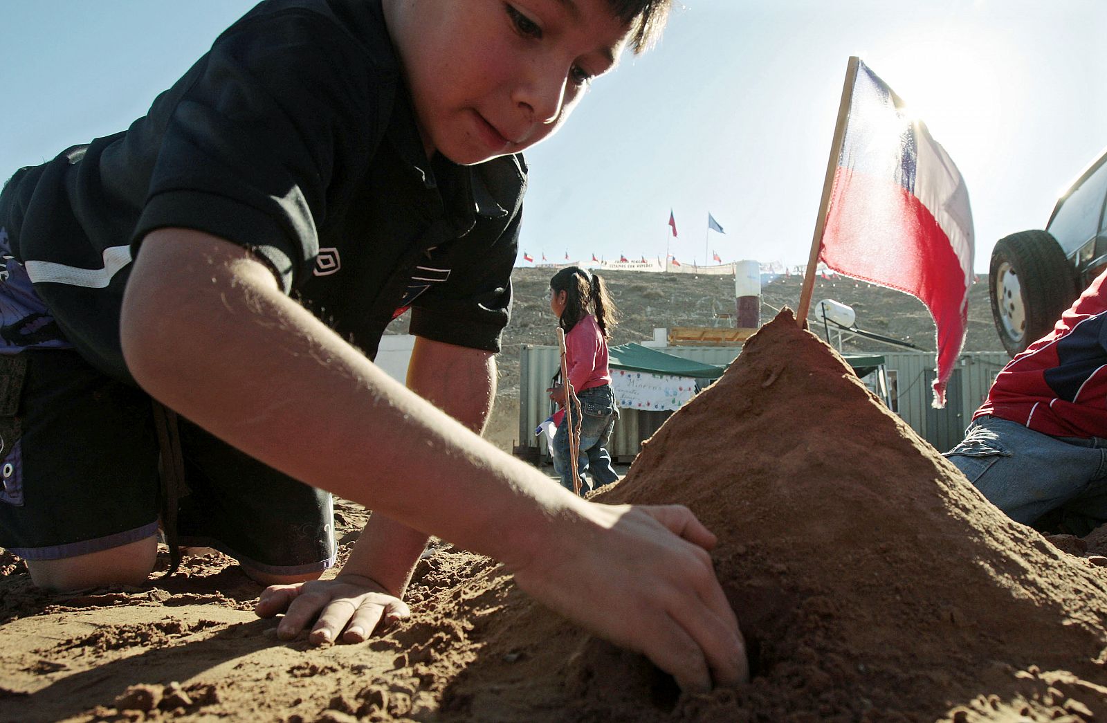 El niño Bruno Avalos hace una representación de arena de la mina San José, donde está atrapado su padre.