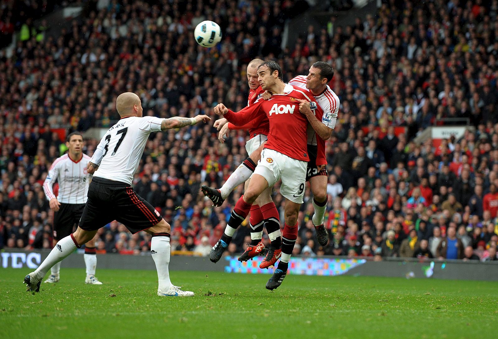 Rooney y Berbatov saltan a por un balón ante Carragher