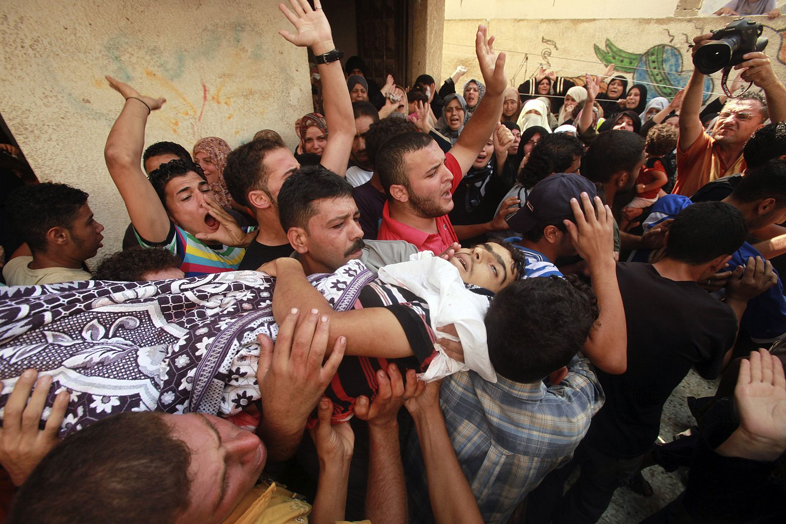 Familiares y amigos transportan el cuerpo sin vida del pescador abatido por la policía israelí en las aguas de Gaza.