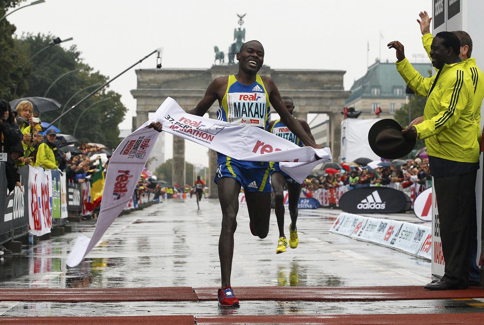 El keniano Patrick Makau cruza la línea para ganar el maratón de Berlín, con la Puerta de Brandeburgo de fondo.