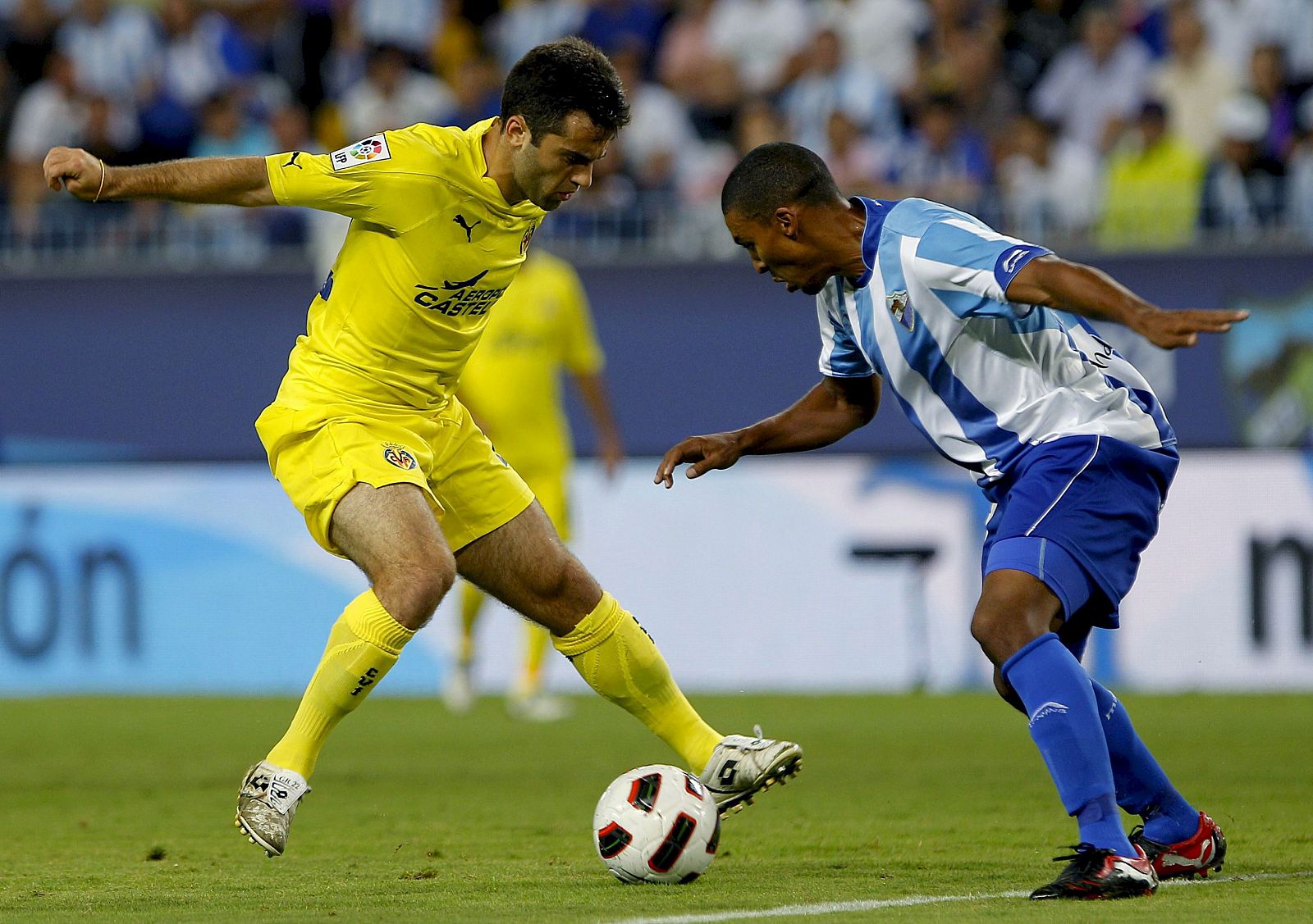 Rossi, del Villarreal, controla el balón frente al defensa malaguista Patrick Mtiliga