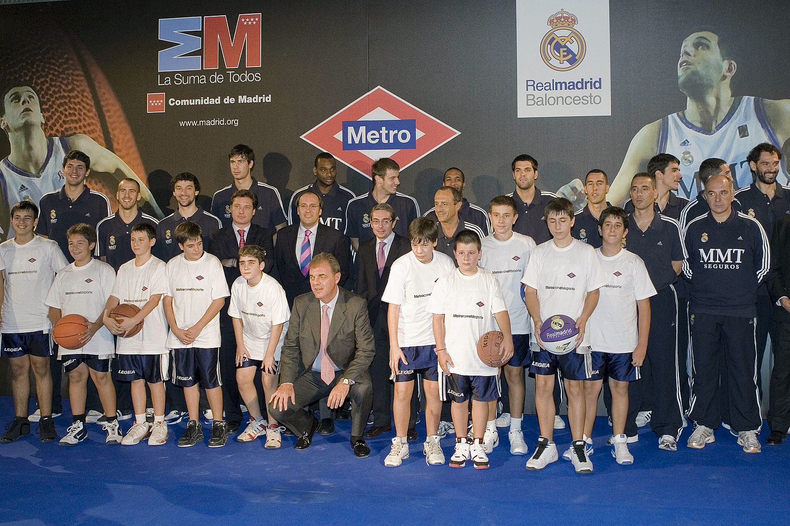 Los jugadores del Real Madrid de baloncesto posan junto a unos alumnos del colegio Virgen de Atocha en la estación de metro de Chamartín (Madrid), donde realizaron una exhibición.