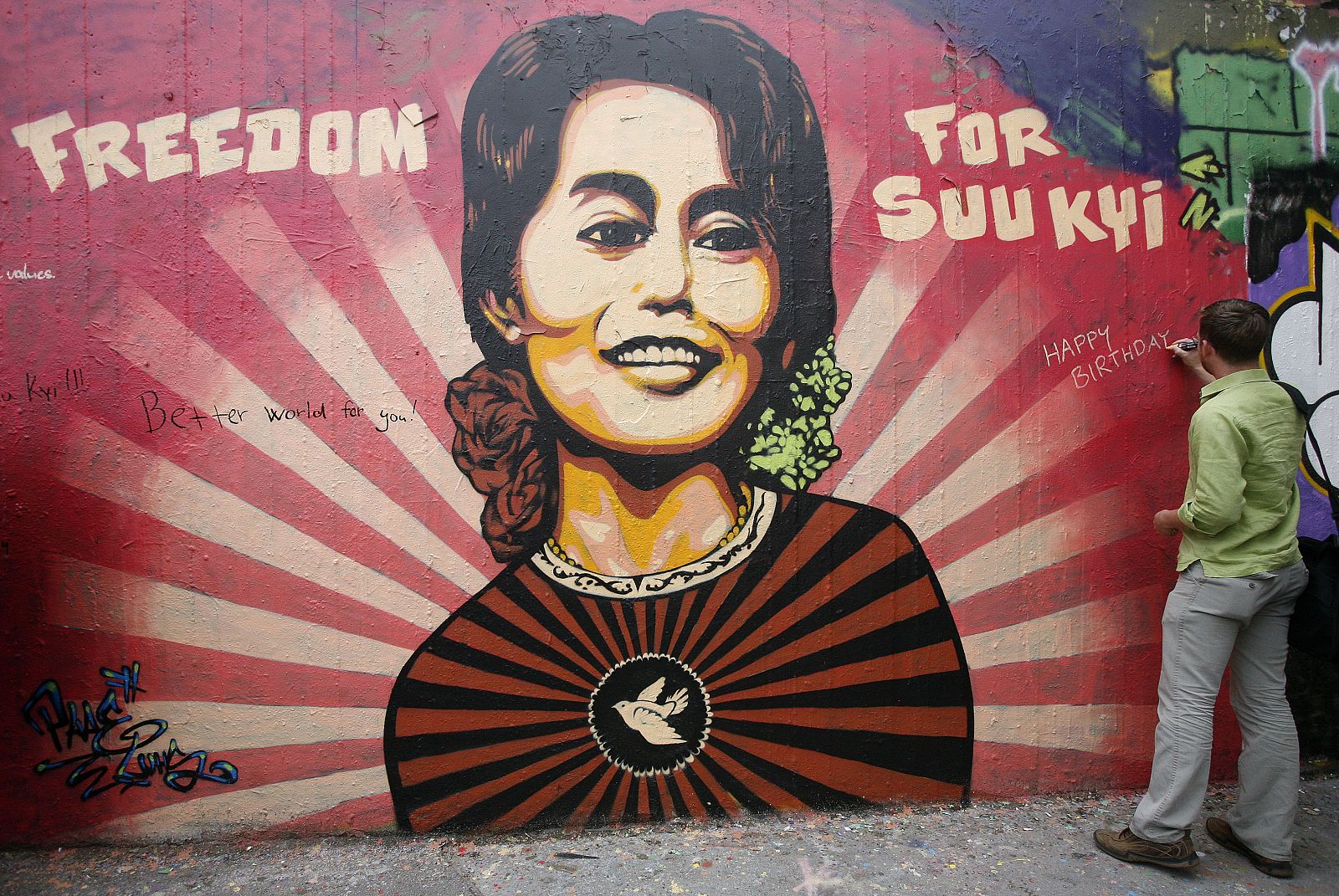 Un hombre deja un mensaje en un mural dedicado a Aung San Suu Kyi en Praga