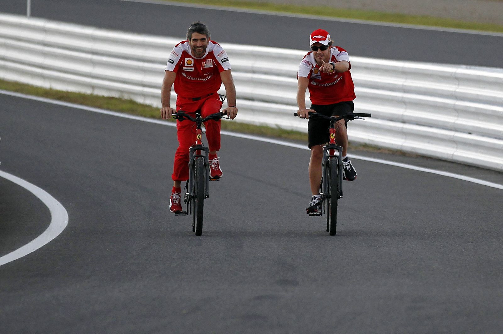 Fernando Alonso recorre la pista de Suzuka en bici con un miembro del equipo Ferrari