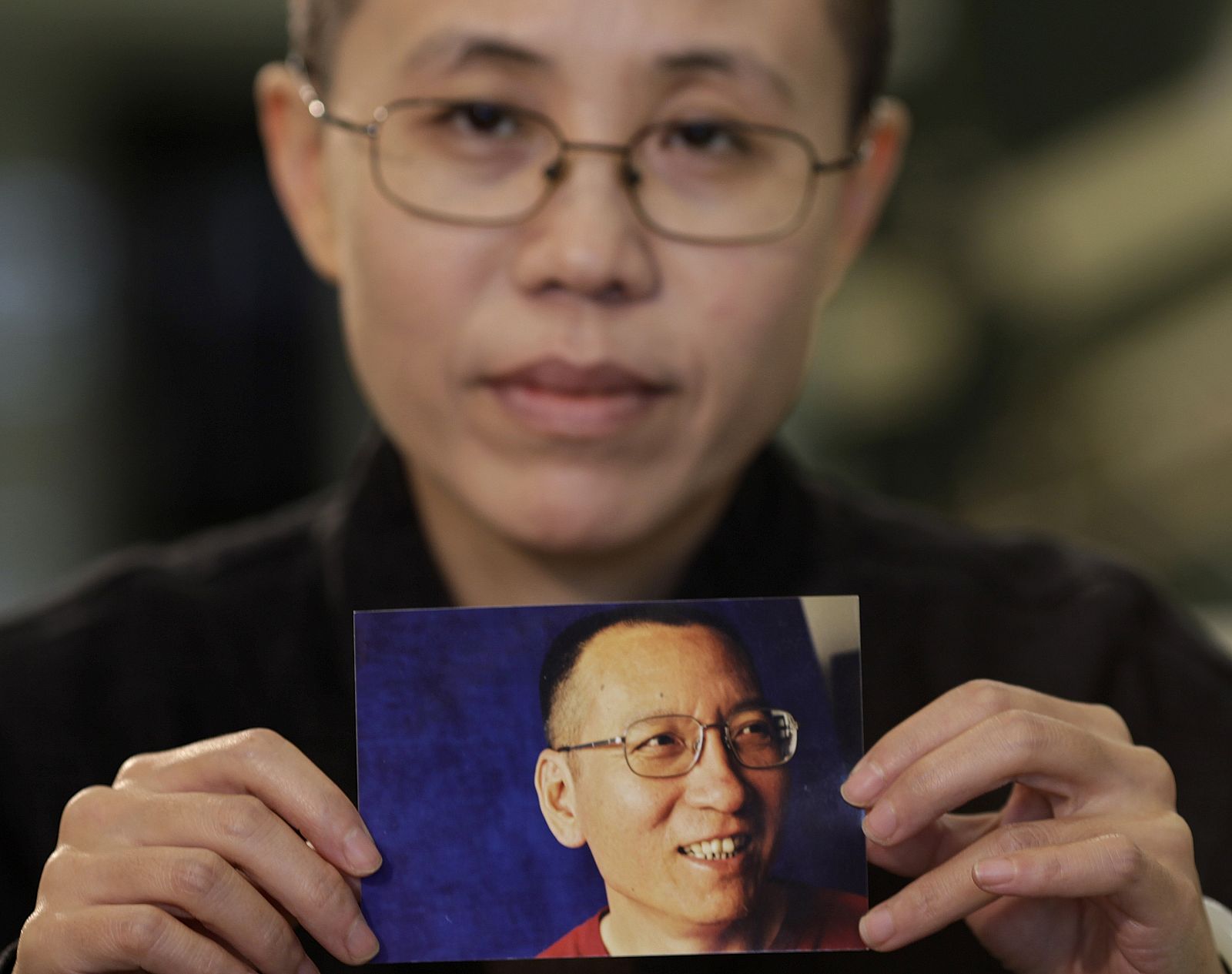 La mujer del disidente chino muestra una foto suya.