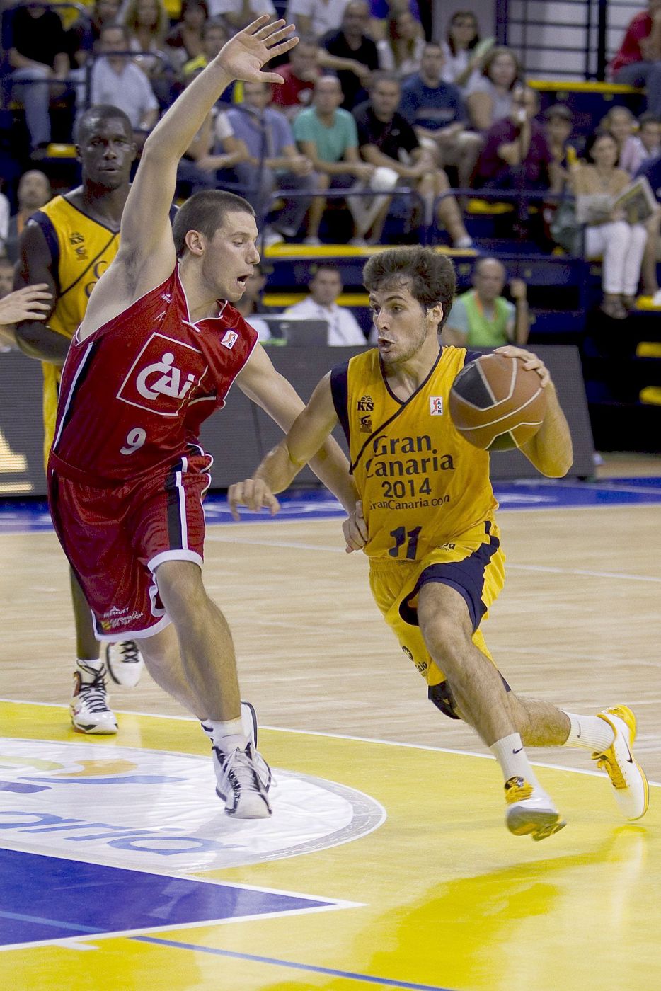 El base del Gran Canaria 2014, Tomás Bellas, intenta penetrar a canasta ante la defensa de Matias Lescano, del Cai Zaragoza.