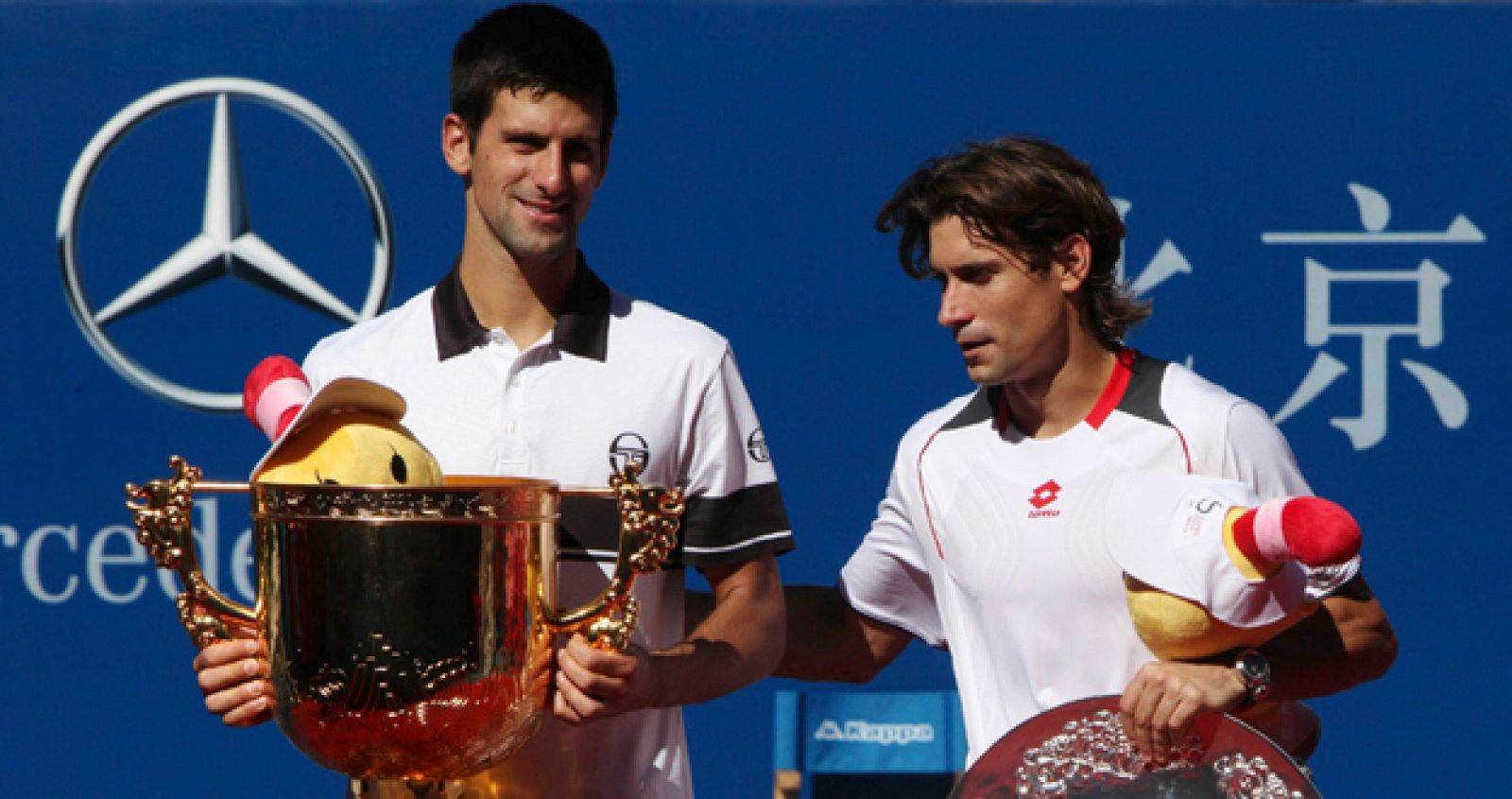 Novak Djokovic y David Ferrer posan para los fotógrafos durante la ceremonia de entrega de trofeos tras disputarse la final del Abierto de China.