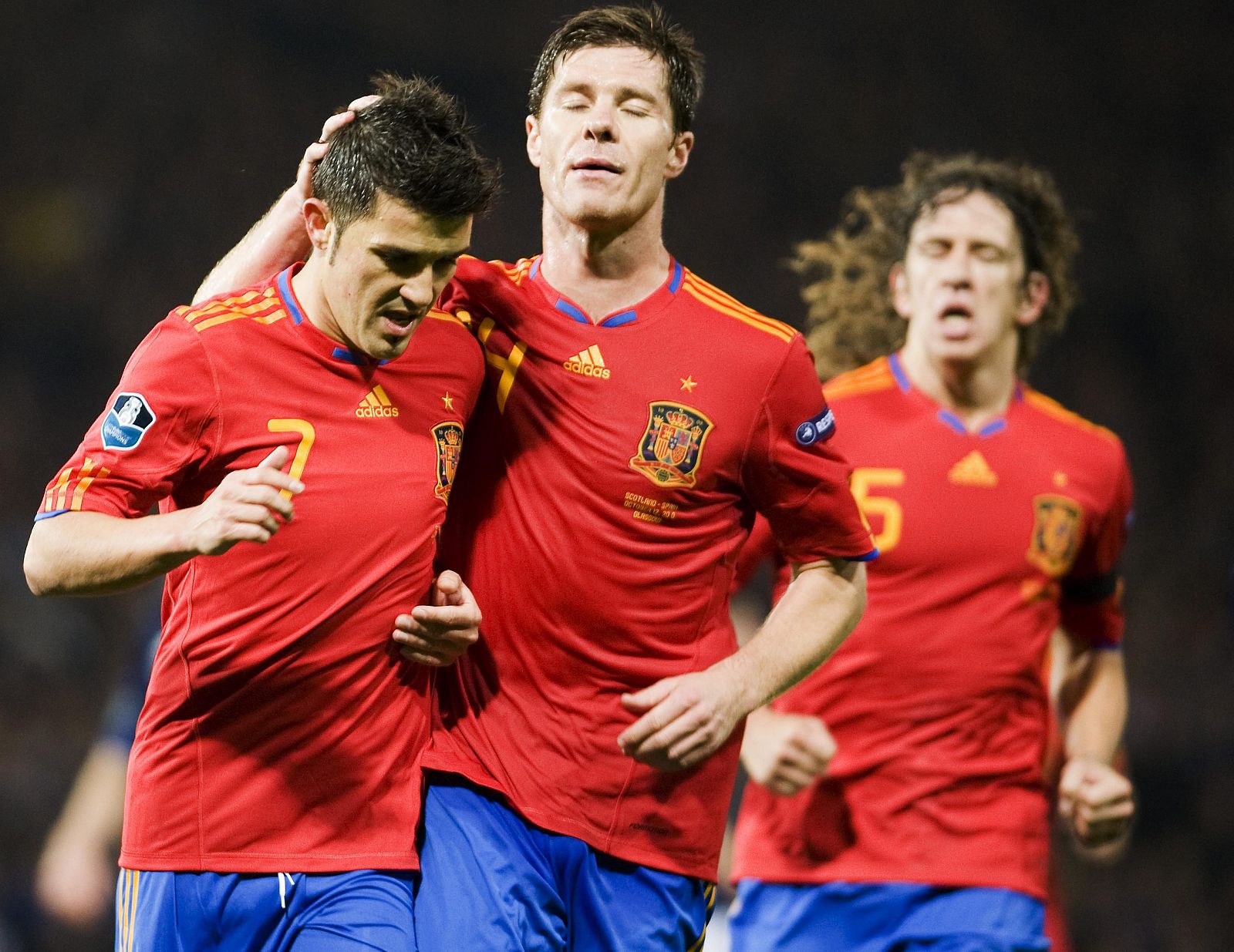 El español David Villa celebra con sus compañeros Xabi Alonso y Carles Puyol después de anotar un gol desde el punto penalti.
