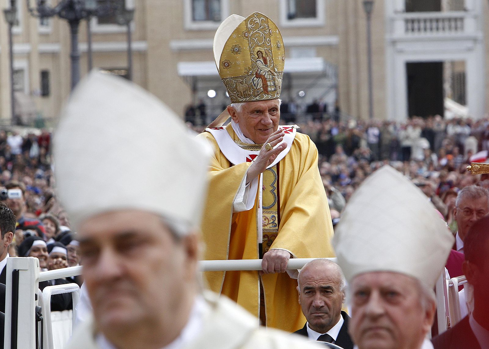 Pope Benedict XVI waves as he arrives to lead a solemn canonisation mass in Saint Peter's square at the Vatican
