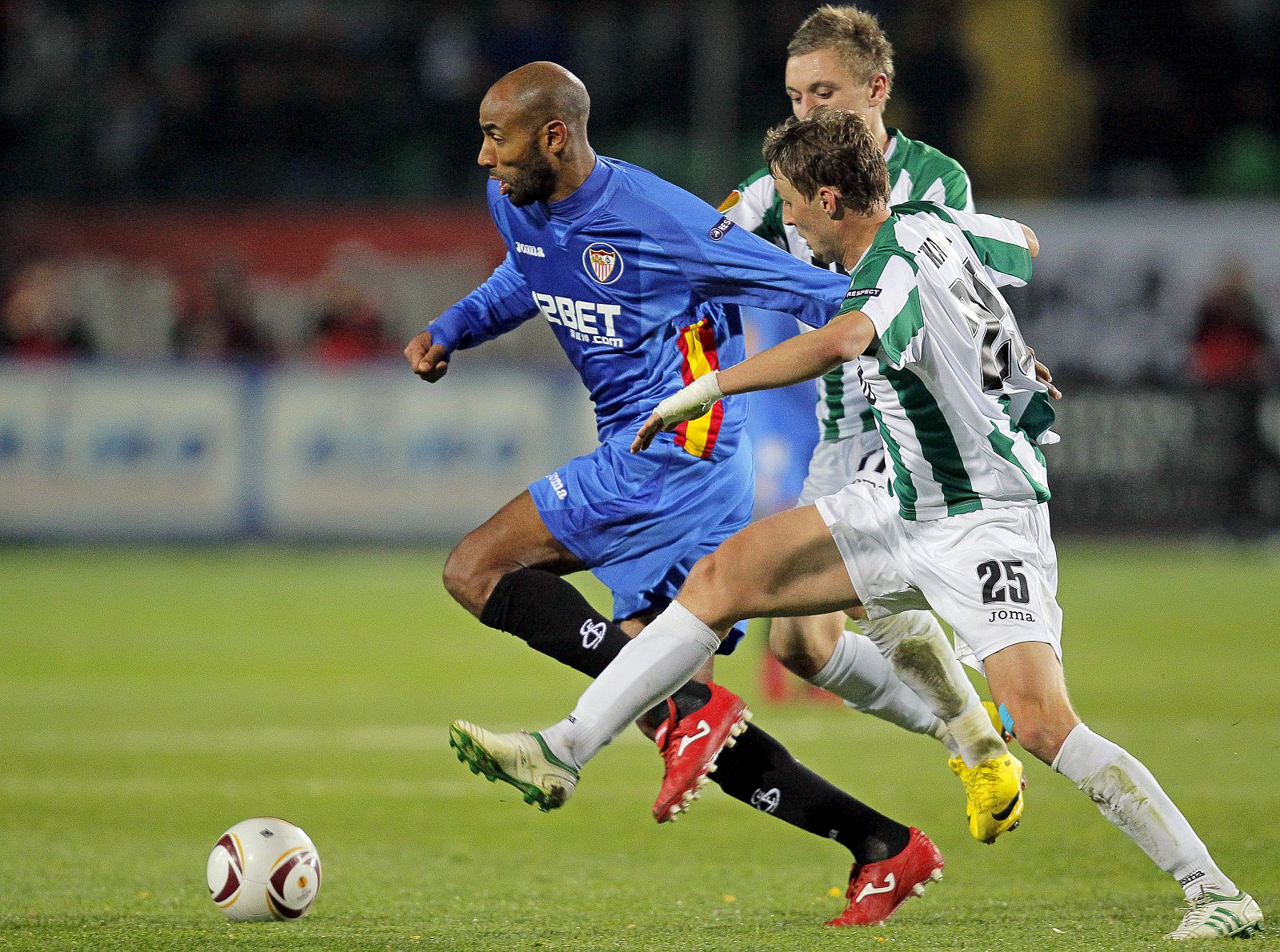 El delantero Freddy Kanouté lucha por el balón con Andriy Tkachuk, del Karpaty.