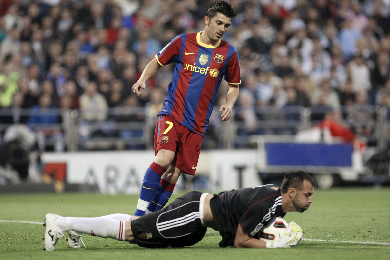 El portero del Zaragoza, Doblas, detiene el balón junto al delantero del Barcelona, David Villa.