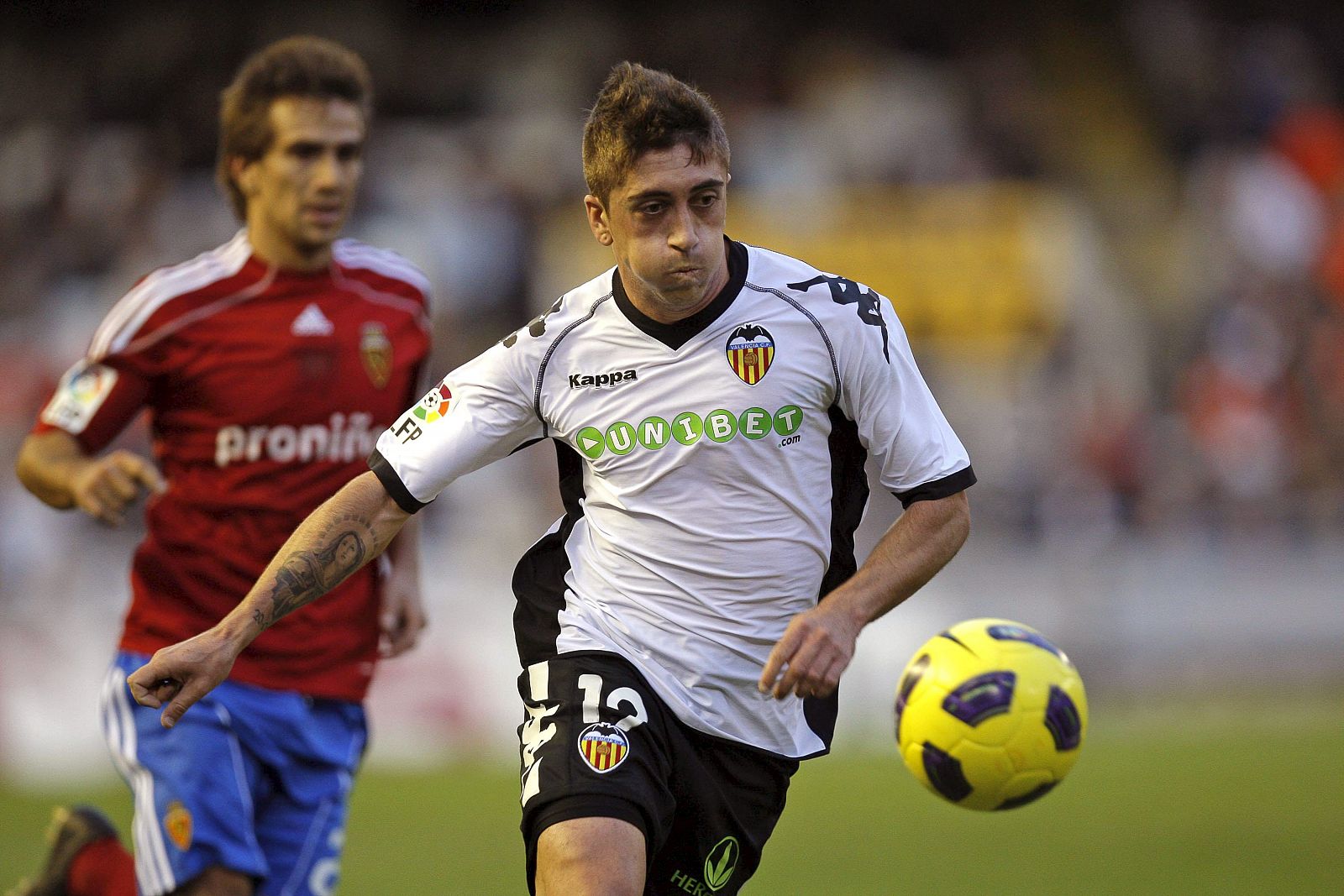 El centrocampista del Valencia, Pablo Hernández (d), avanza con el balón bajo la presión del centrocampista argentino del Zaragoza Leonardo Ponzio