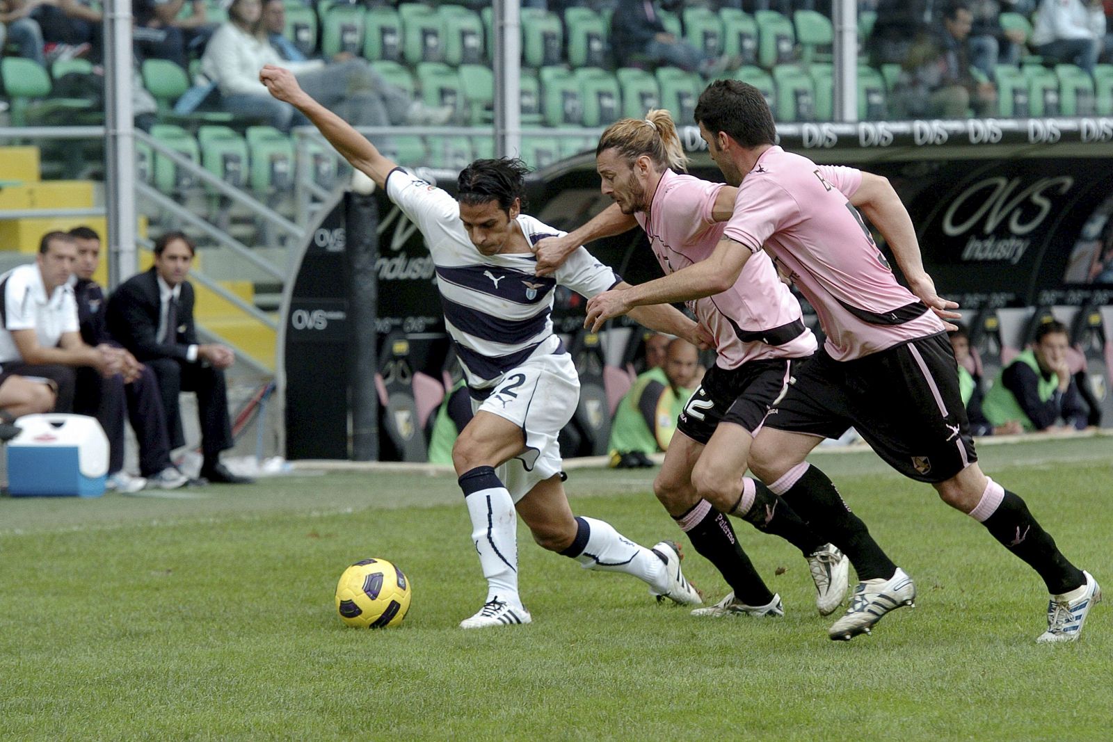 El jugador Federico Balzaretti (c), del Palermo, y Sergio Floccari (izda), del Lazio, pelean por la posesión del balón