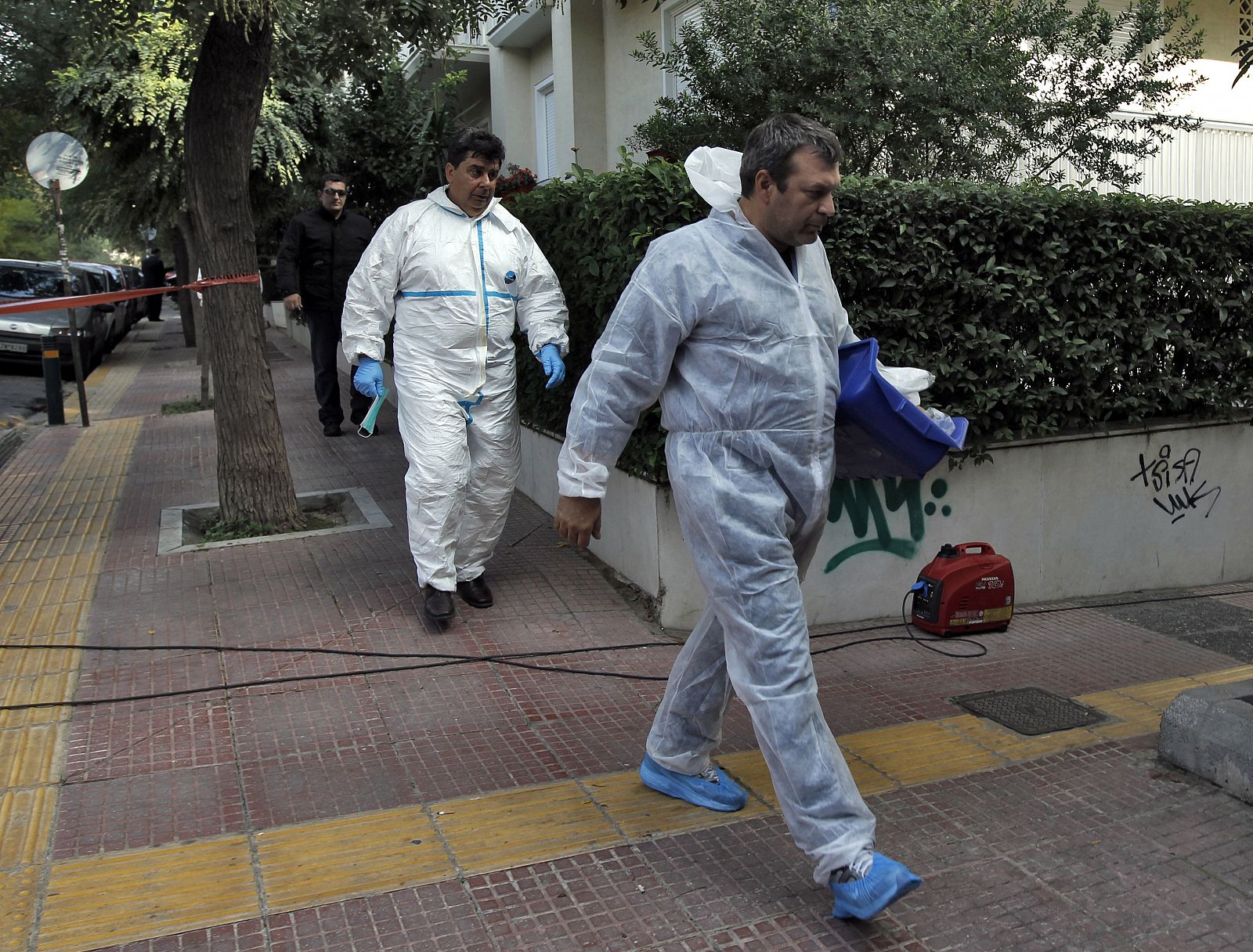 Investigators leave the Swiss Embassy in Athens after a bomb alert