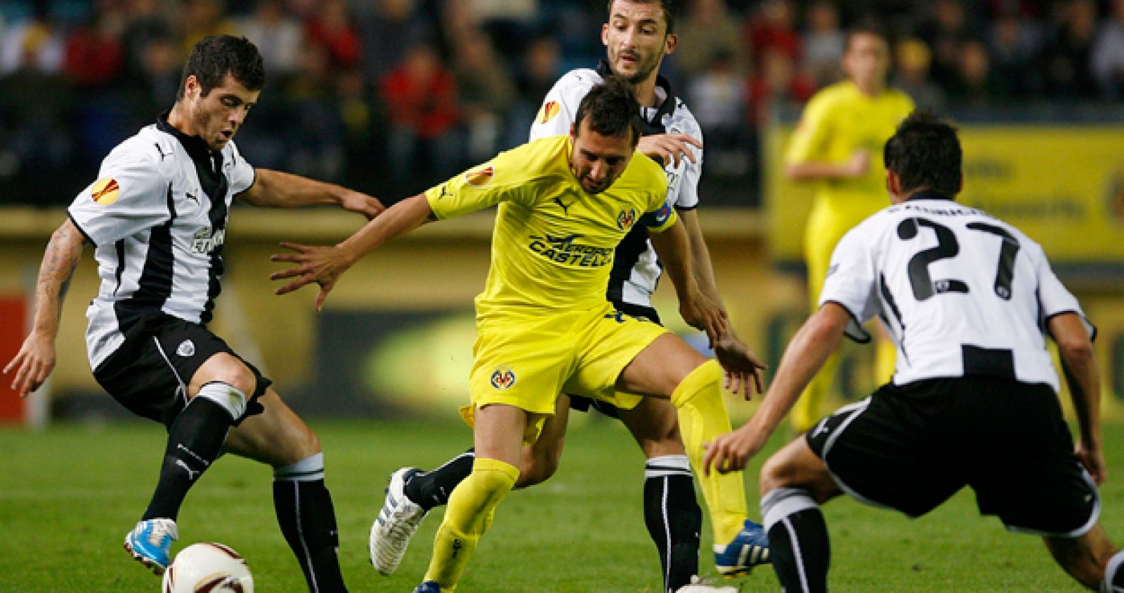 El jugador del Villarreal, Santi Cazorla, rodeado por varios jugadores, intenta controlar el balón,