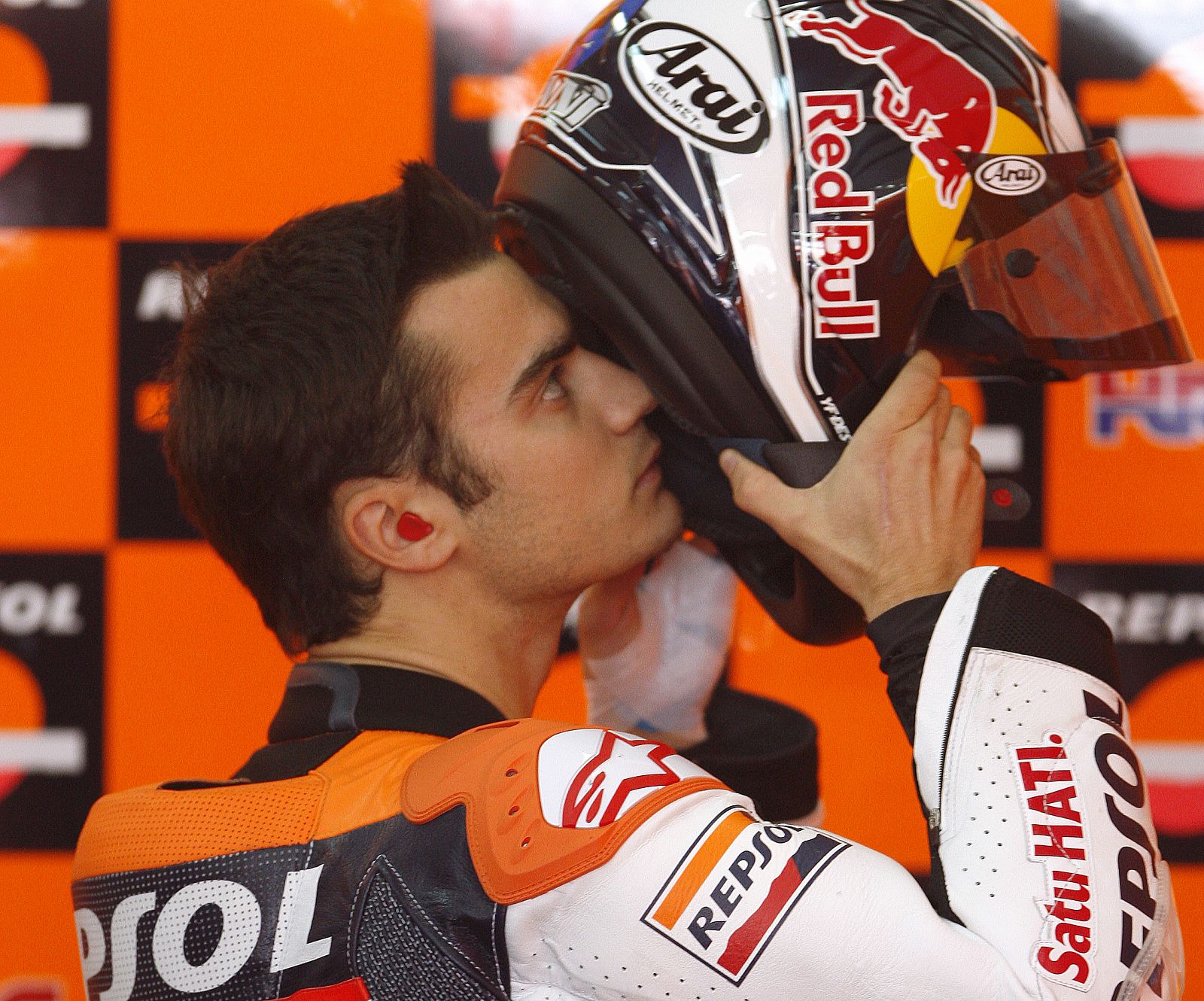 Honda MotoGP rider Dani Pedrosa of Spain puts on his helmet before the second free practice session in Valencia