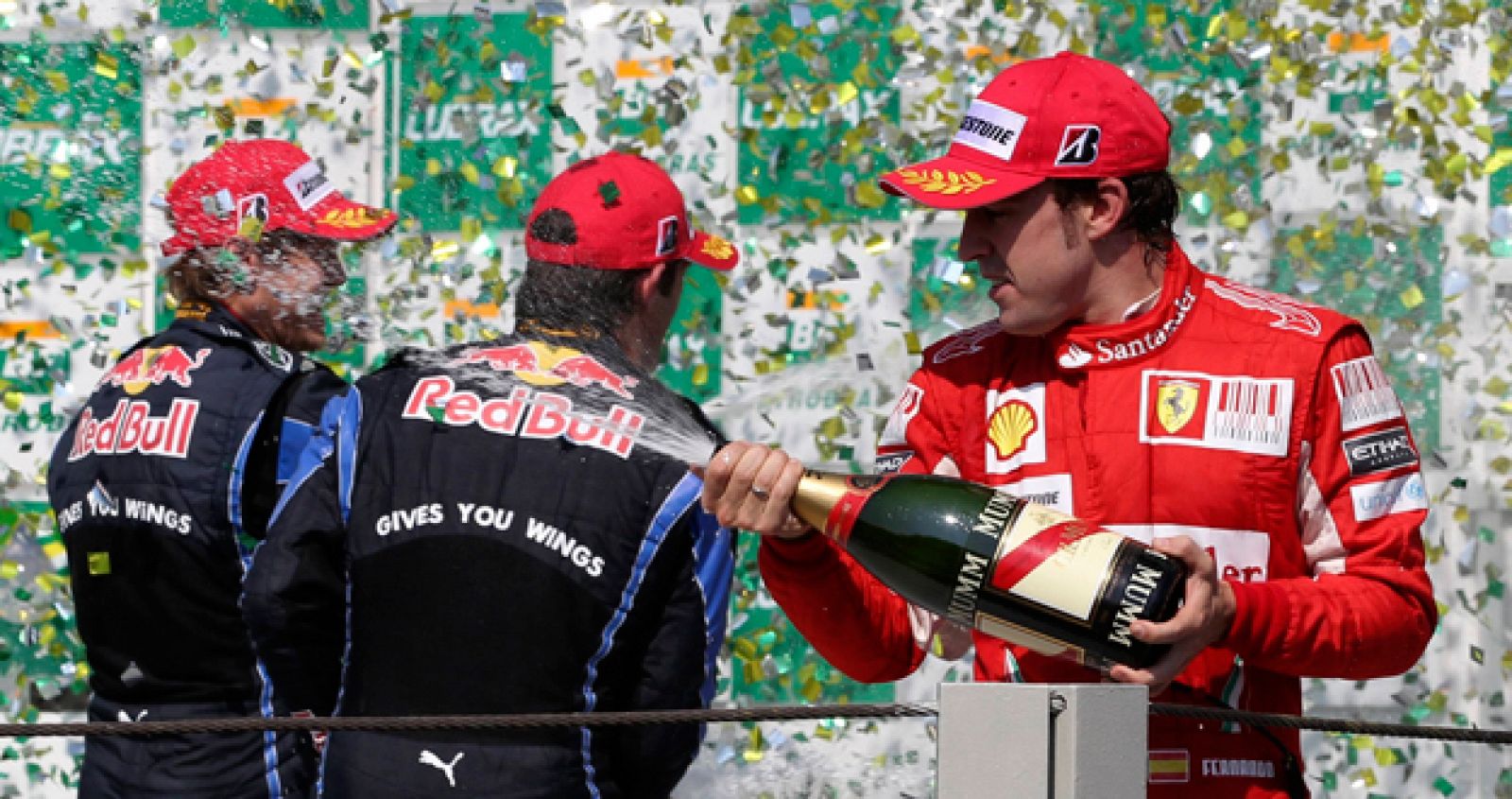 Fernando Alonso celebra en el podio su tercer puesto en el circuito brasileño de Interlagos donde Vettel fue primero y Webber segundo.