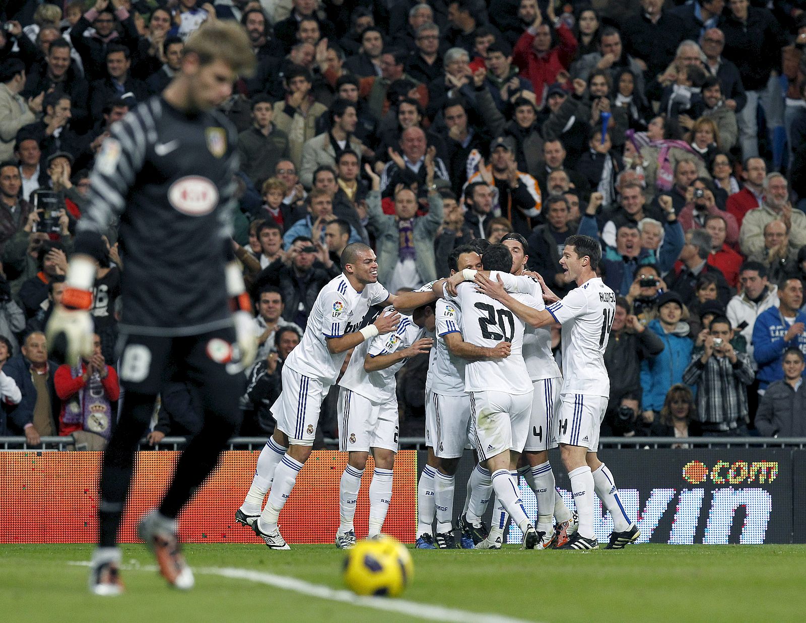 Los jugadores del Real Madrid celebran su primer gol, obra del defensa portugués Ricardo Carvalho, en presencia del portero del Atlético de Madrid, David de Gea.