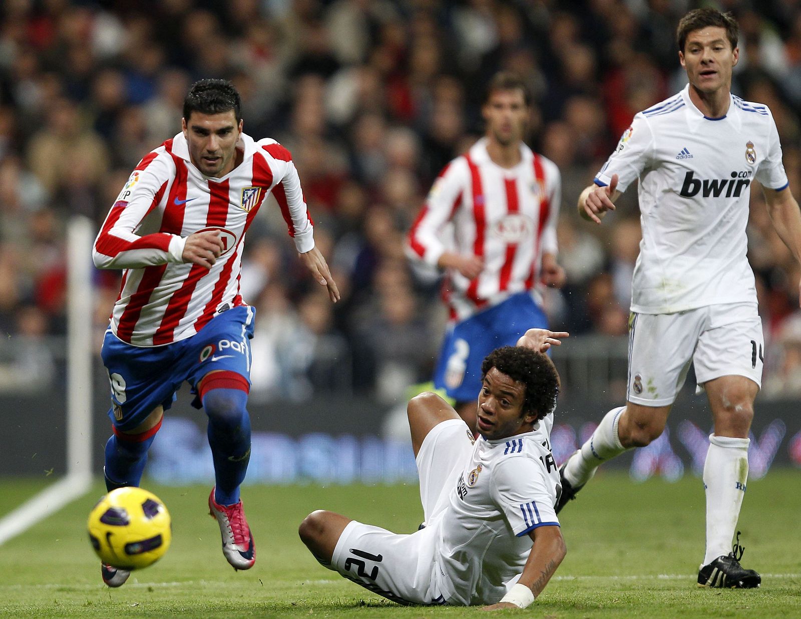 José Antonio Reyes conduce el balón ante la mirada de Xabi Alonso en el derbi madrileño jugado en el Bernabéu.