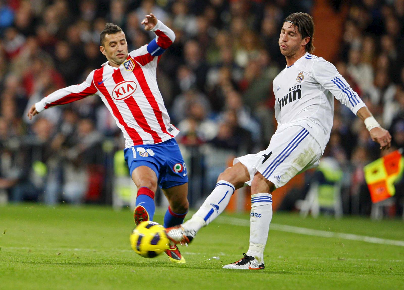 El defensa del Real Madrid Sergio Ramos pelea un balón con el centrocampista portugués del Atlético de Madrid Simao Sabrosa.