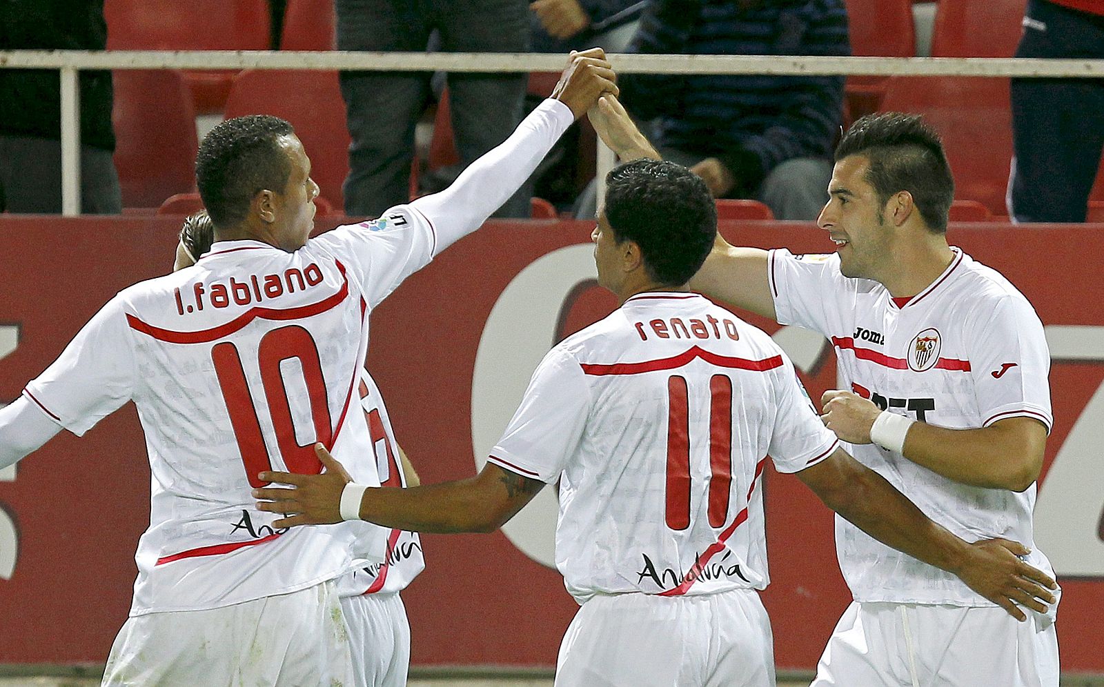 Los jugadores brasileños del Sevilla Luis Fabiano y Renato  felicitan a Álvaro Negredo tras marcar el primer gol ante el Valencia.