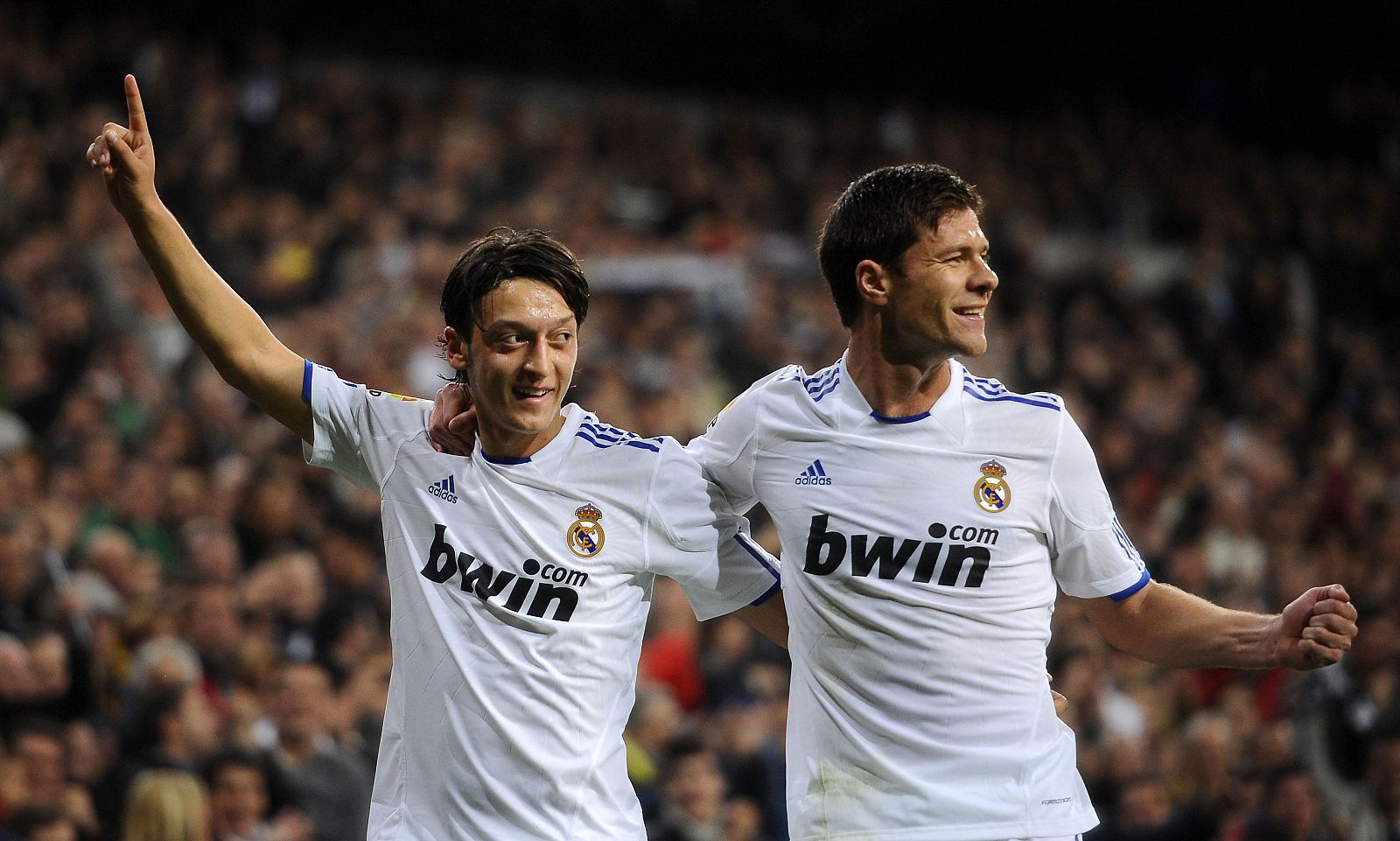 Özil celebra uno de los dos goles del Real Madrid frente al Atleti con Xabi Alonso.