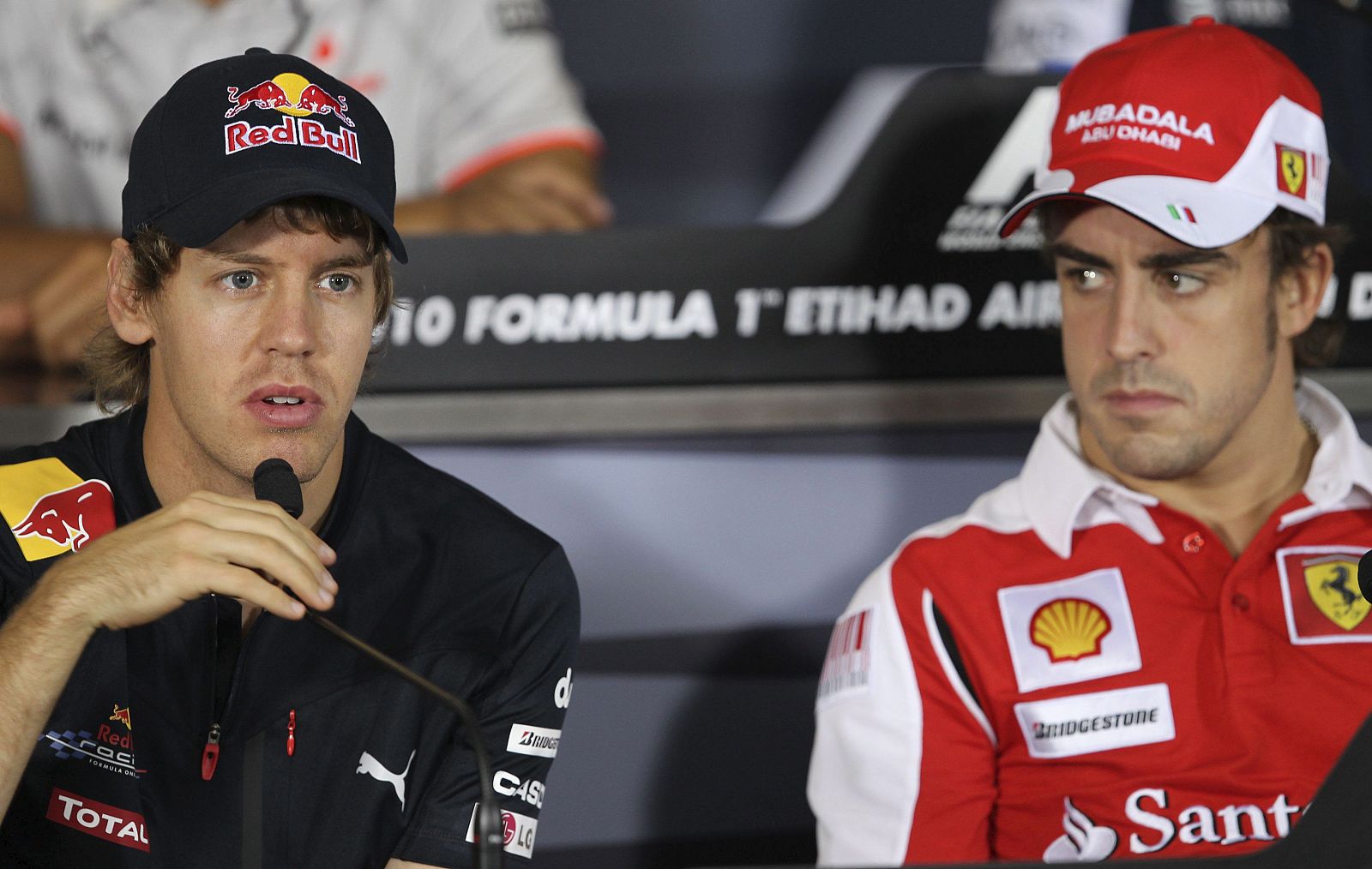 Fernando Alonso (d) escucha al alemán Sebastian Vettel (Red Bull), durante la rueda de prensa celebrada en el circuito Yas Marina de Abu Dabi.
