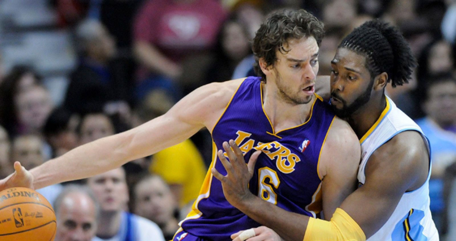 El jugador español de los Los Ángeles Lakers Pau Gasol protege el balón frente a Nene, de los Nuggets de Denver.