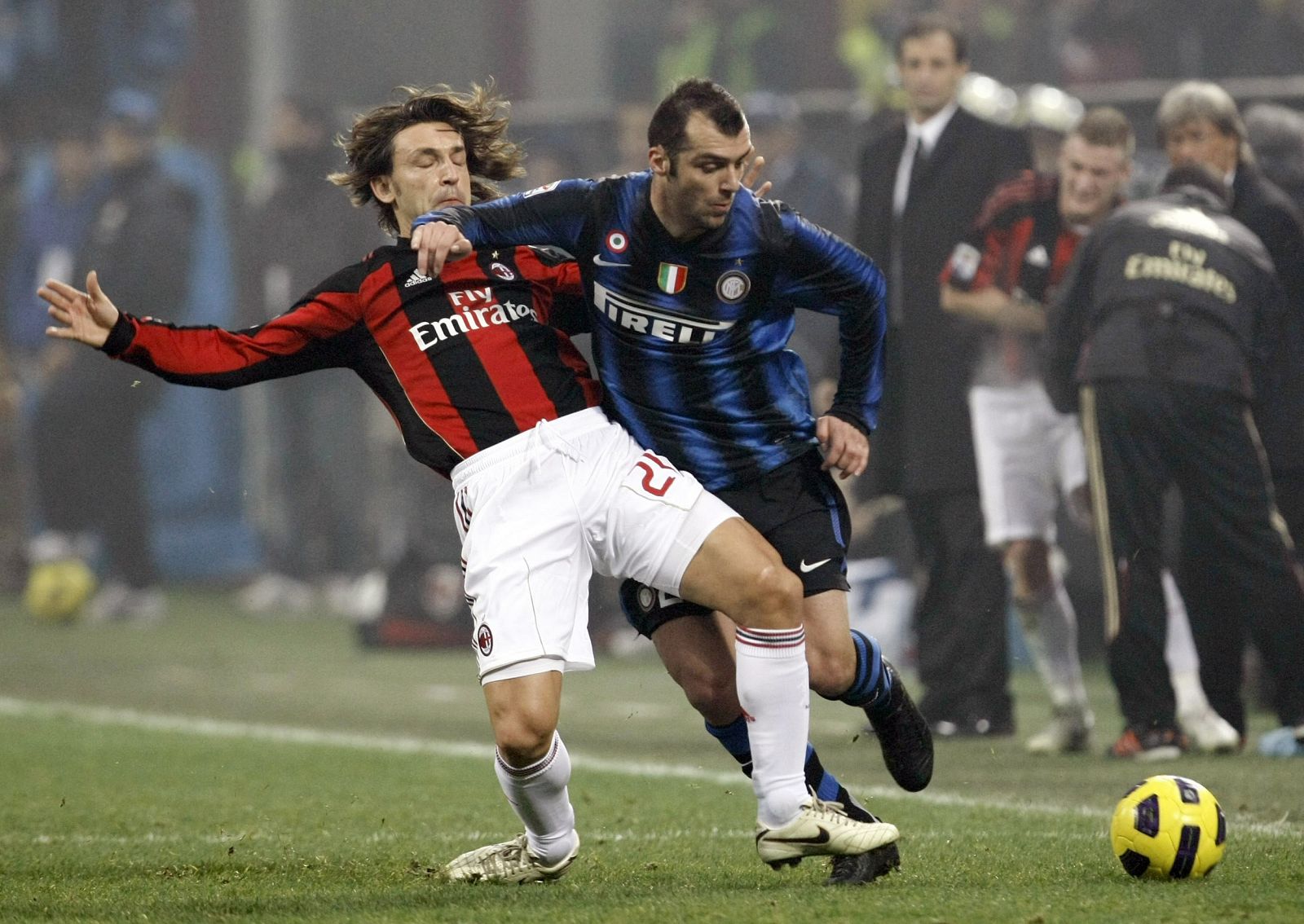 El jugador del Milan, Pirlo, disputa el balón con el futbolista del Inter, Pandev, en el derbi italiano.