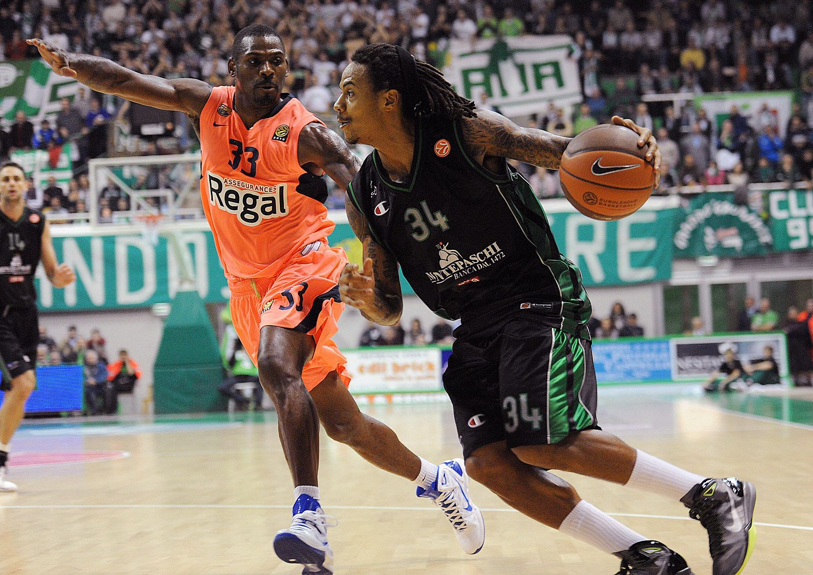 El jugador del Montepaschi Siena David Moss (d) controla el balón ante la marca de Pete Mickeal