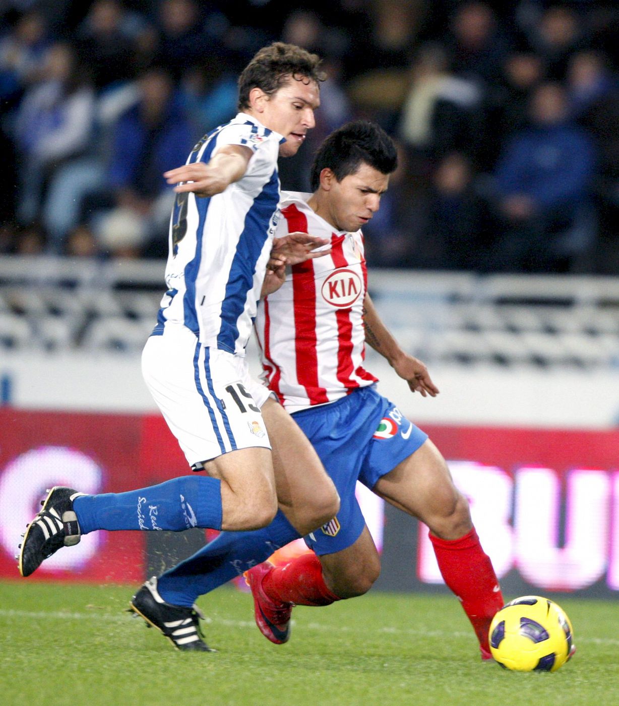 El defensa de la Real Sociedad Ion Ansotegui (i) y el delantero argentino del Atlético de Madrid Sergio Leonel Agüero (atrás) luchan por el balón.