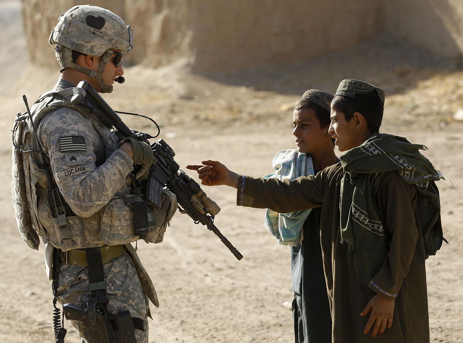 Un militar estadounidense charla con dos jóvenes afganos en Kandahar.