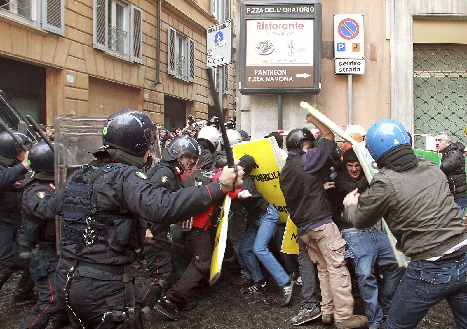 Estudiantes italianos se enfrentan a agentes de la policía antidisturbios durante una manifestación cerca de la sede del partido de Silvio Berlusconi.