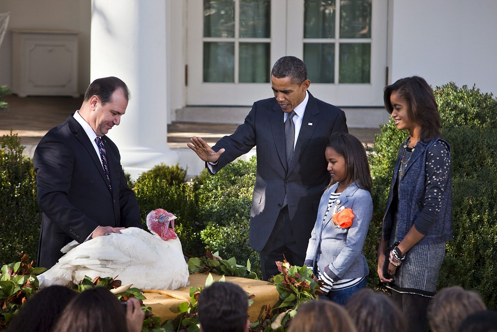 El presidente de los EE.UU. Barack Obama (c), junto con sus hijas Sasha (c-dcha.) y Maila (dcha.), indulta al pavo dentro de la tradición de Acción de Gracias