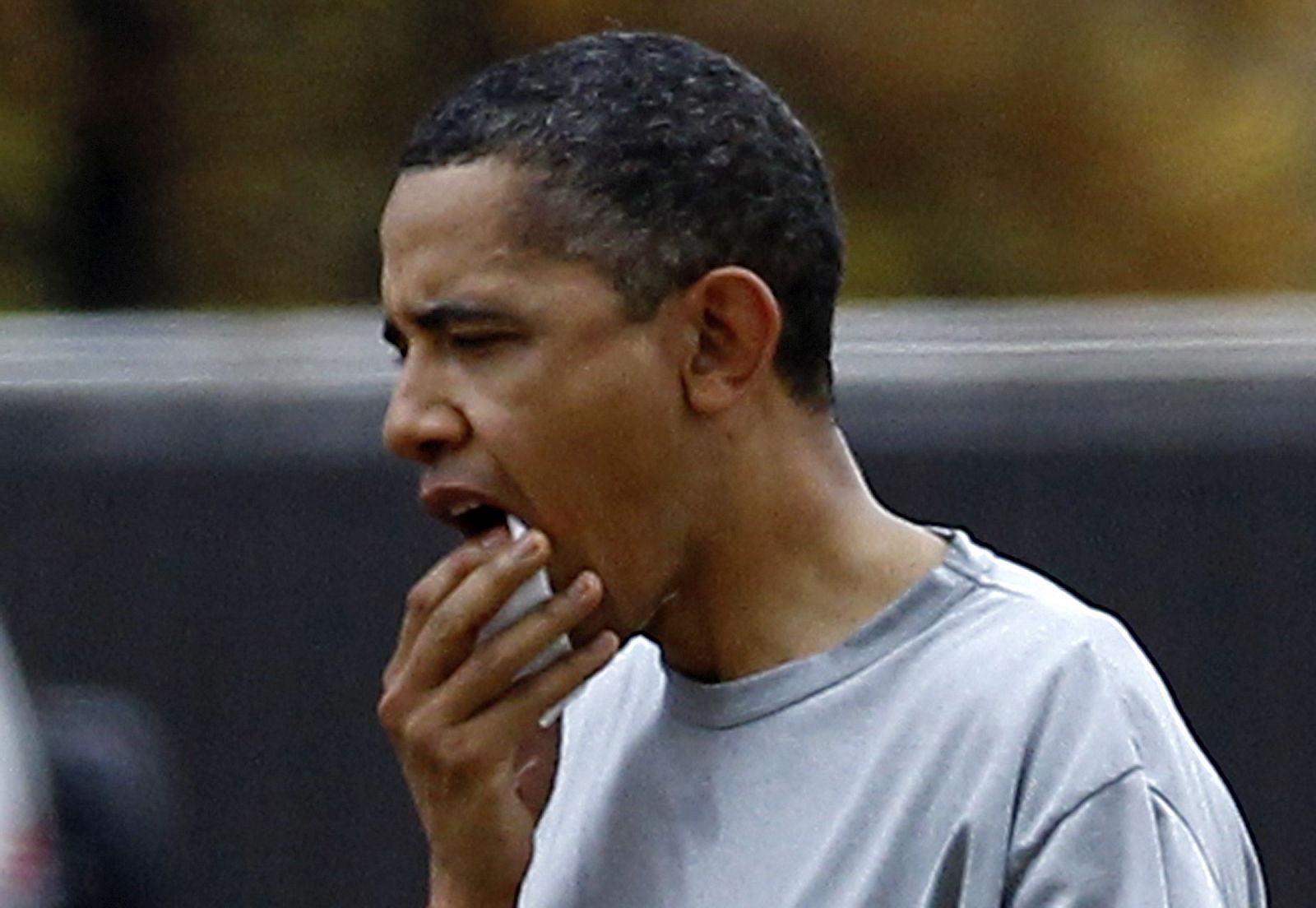 El presidente de EE.UU., Barack Obama, muestra un gesto de dolor al recibir un golpe en el labio en un partido de baloncesto.