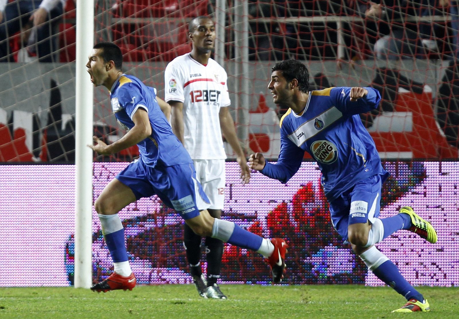 Mimu celebra su gol ante el Sevilla, seguido de Miguel Torres ante la mirada del sevillista Konko