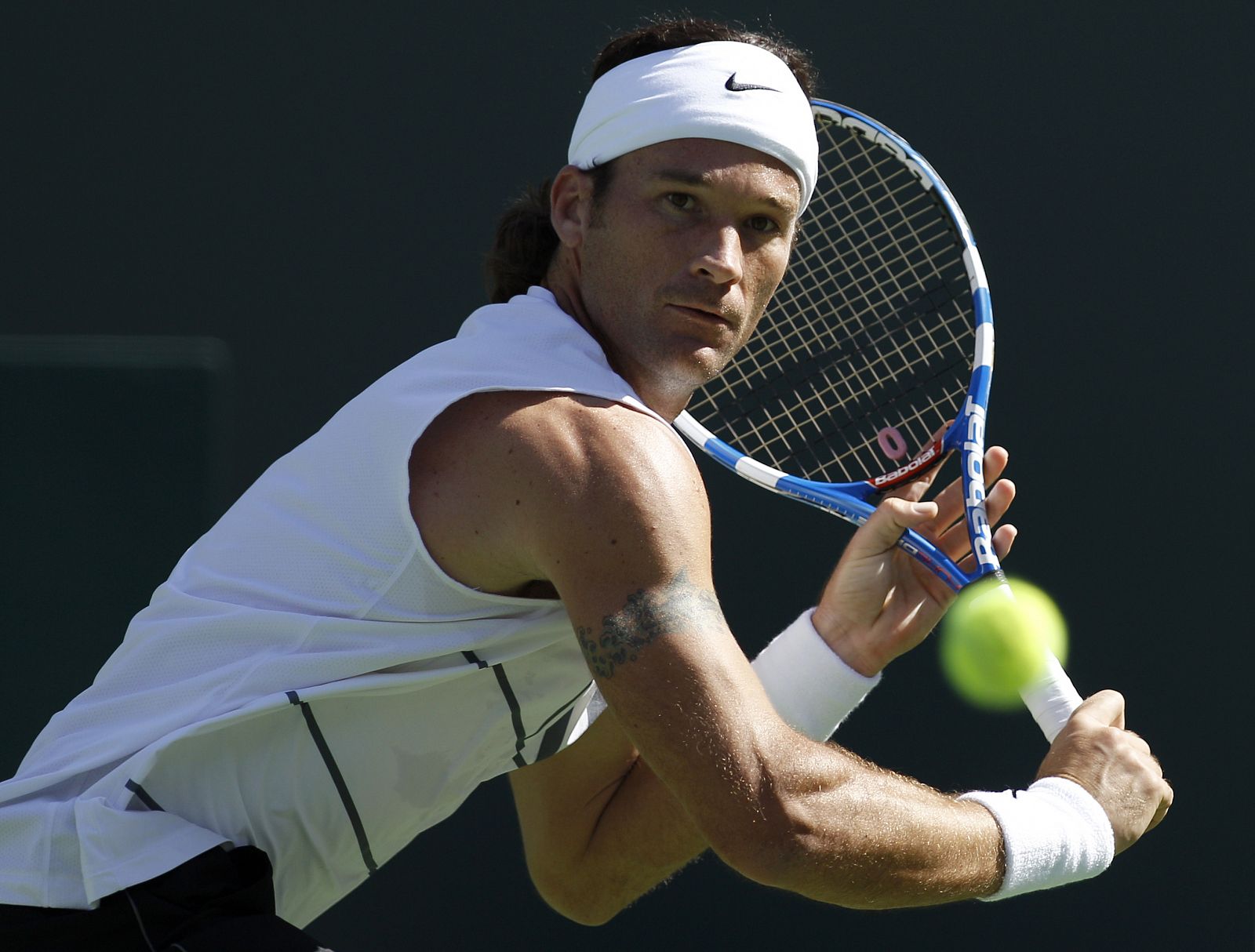 Carlos Moya of Spain runs down the ball against Tim Smyczek of the U.S. during their match at the Indian Wells ATP tennis tournament in Indian Wells